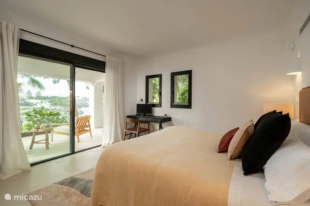 Lower floor bedroom, air conditioning, wardrobes. En-suite bathroom with shower, double sink, hairdryer, towels, products. French doors to a terrace with sea views.