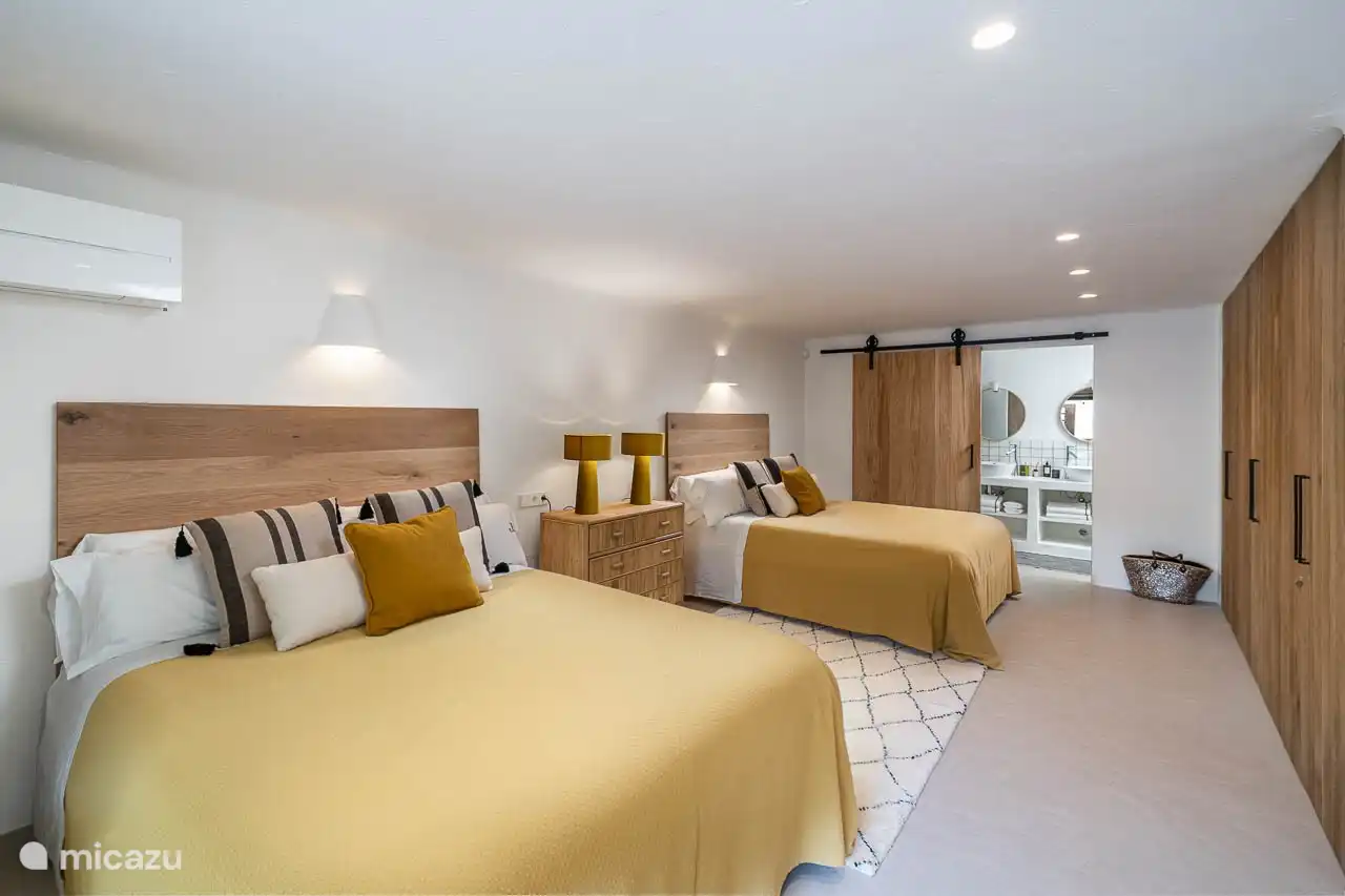 Ground floor bedroom, air conditioning, wardrobes. En-suite bathroom with shower, double sink, hairdryer, towels, products. French doors to the entrance of the villa.
