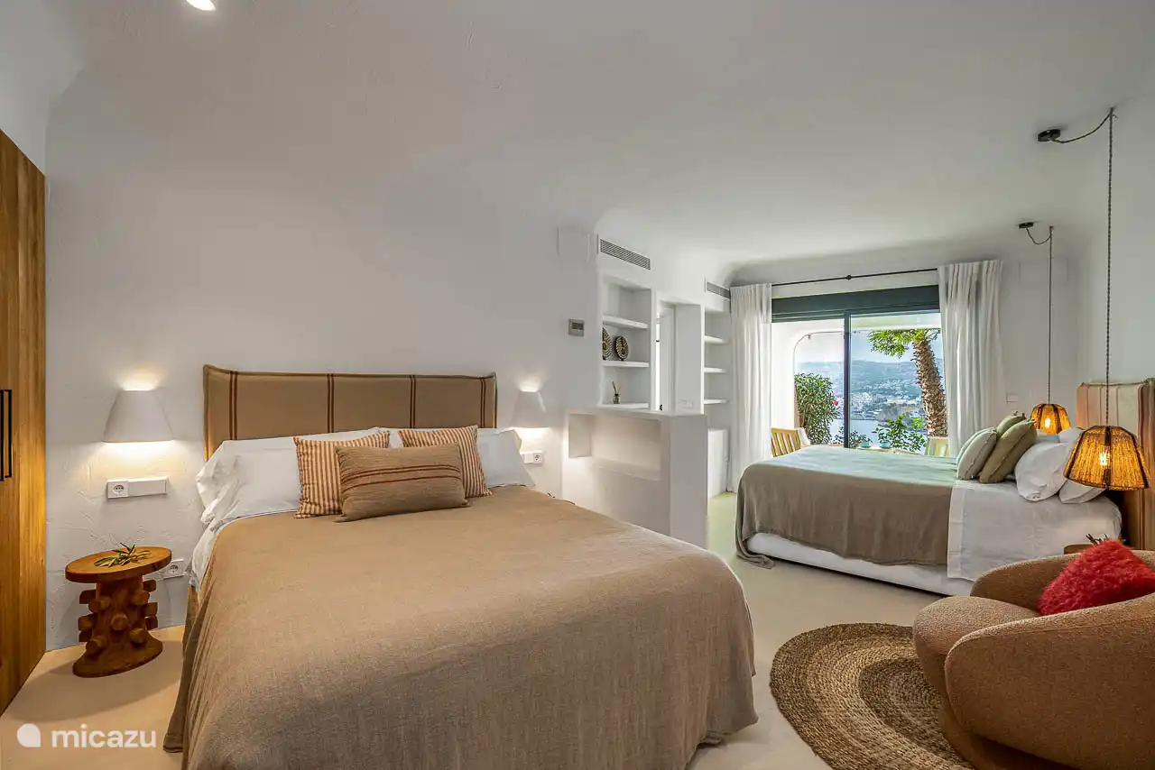 Lower floor bedroom, air conditioning, wardrobes. En-suite bathroom with shower, double sink, hairdryer, towels, products. French doors to a terrace with sea views.