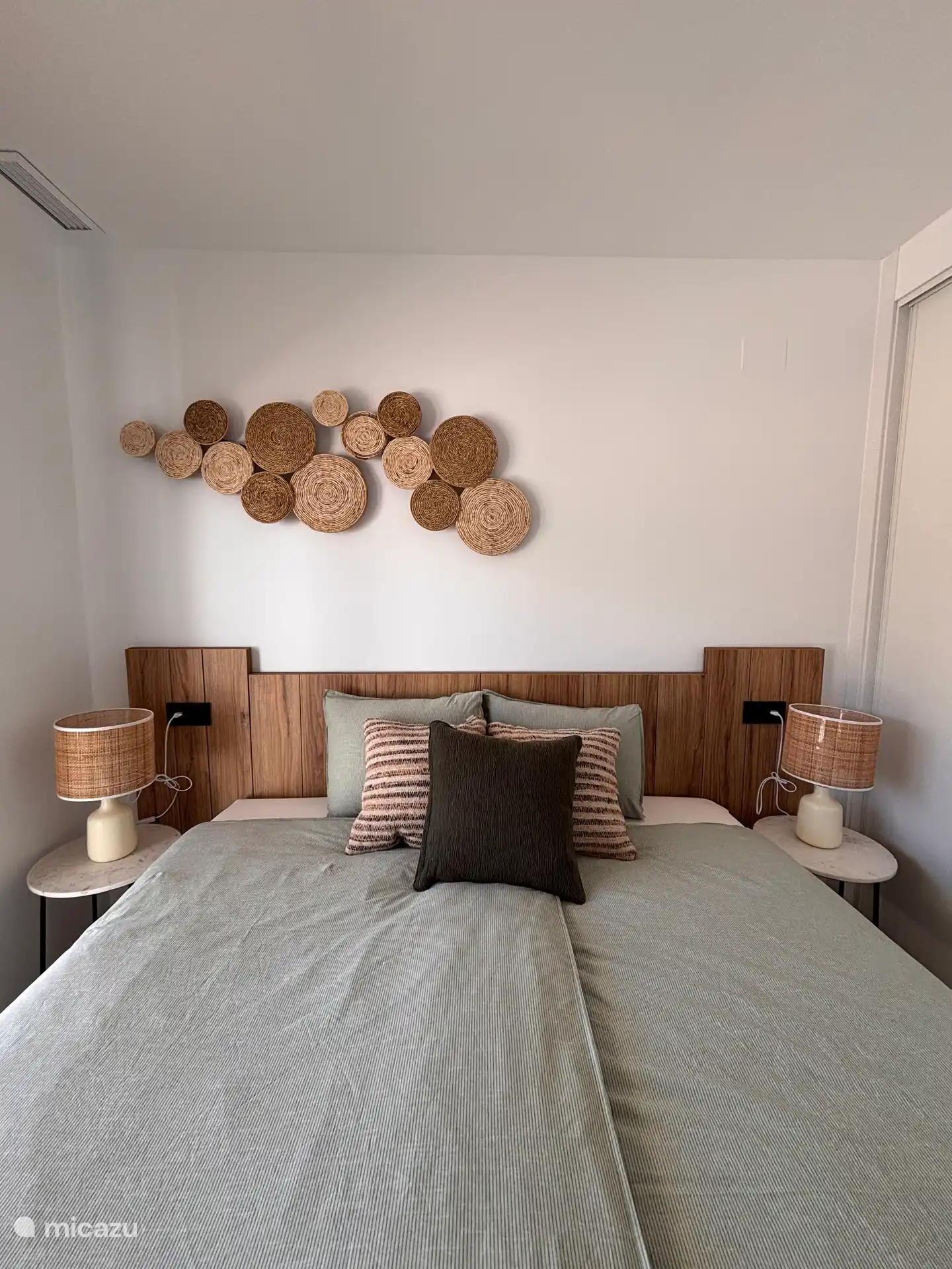 Primer dormitorio con ropa de cama limpia y un colchón cómodo con topper. 