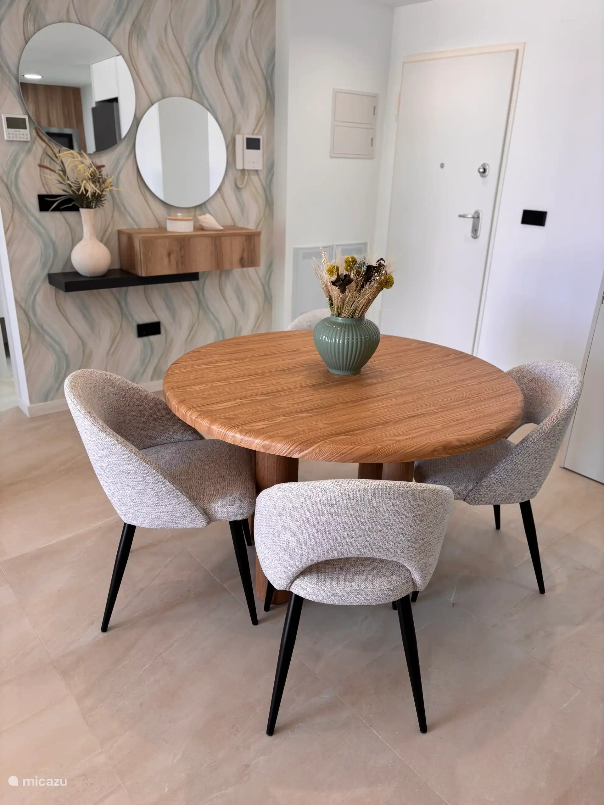 Mesa redonda de comedor con cuatro cómodas sillas de comedor. 