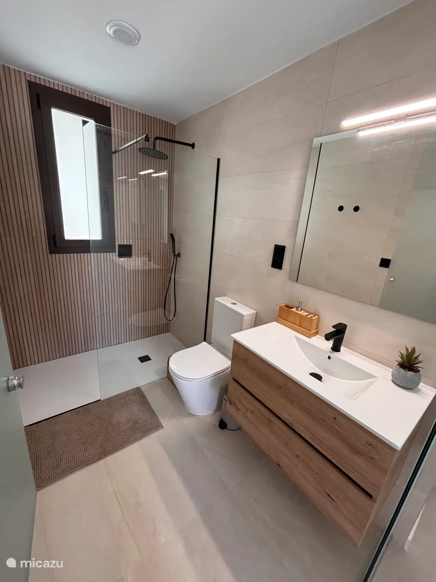 Segundo baño en suite con inodoro, muebles y una ducha de lluvia preciosa. 