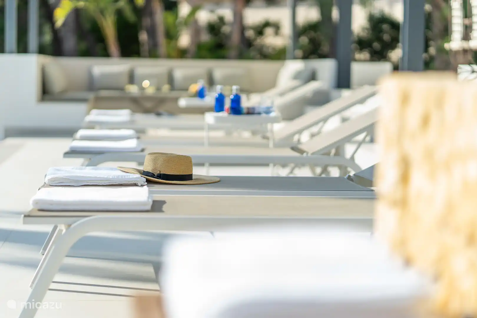 Swimming pool surrounded by a terrace with sun loungers, sea view.