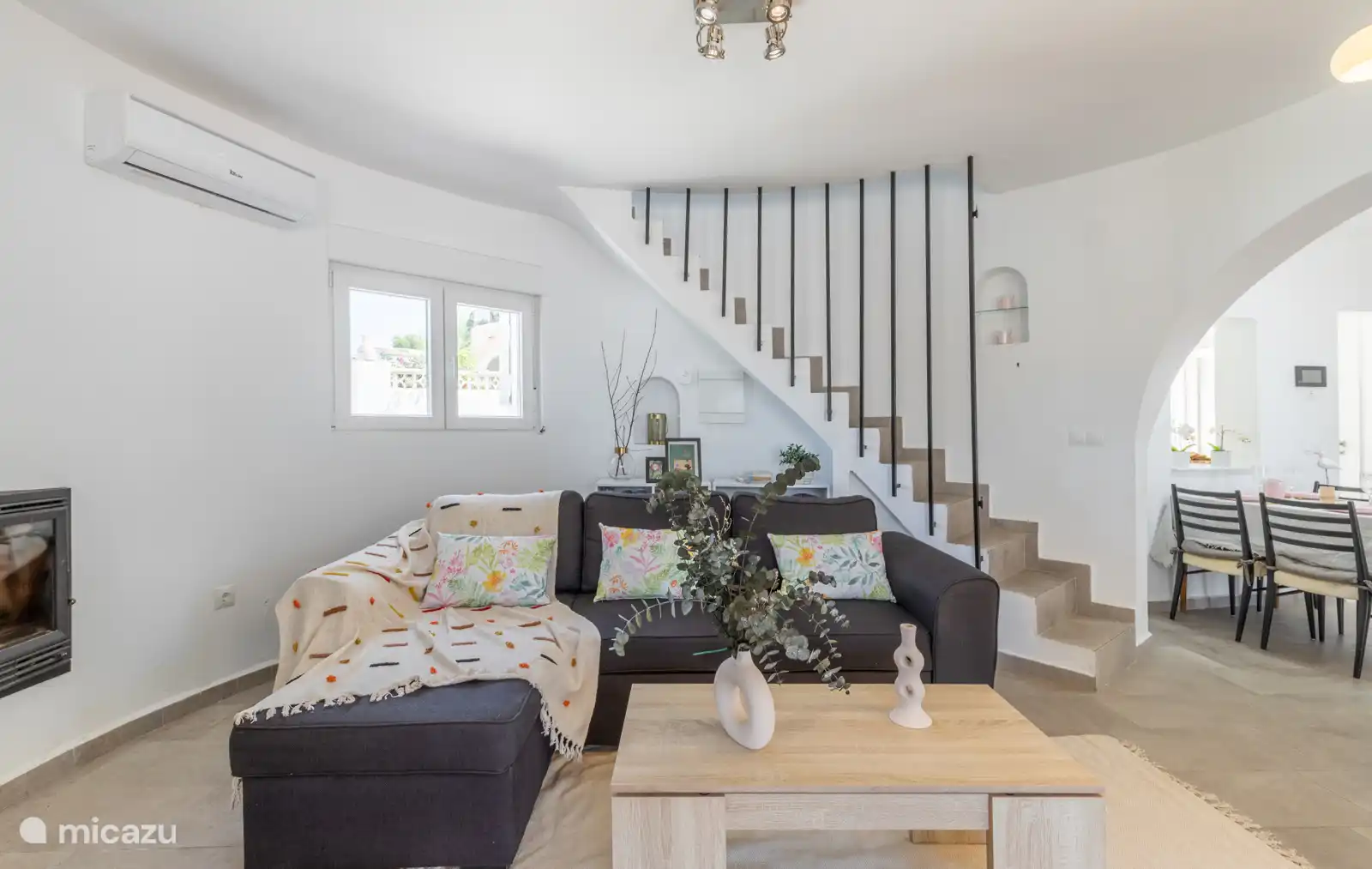 Sofá y escalera del salón hacia la segunda planta