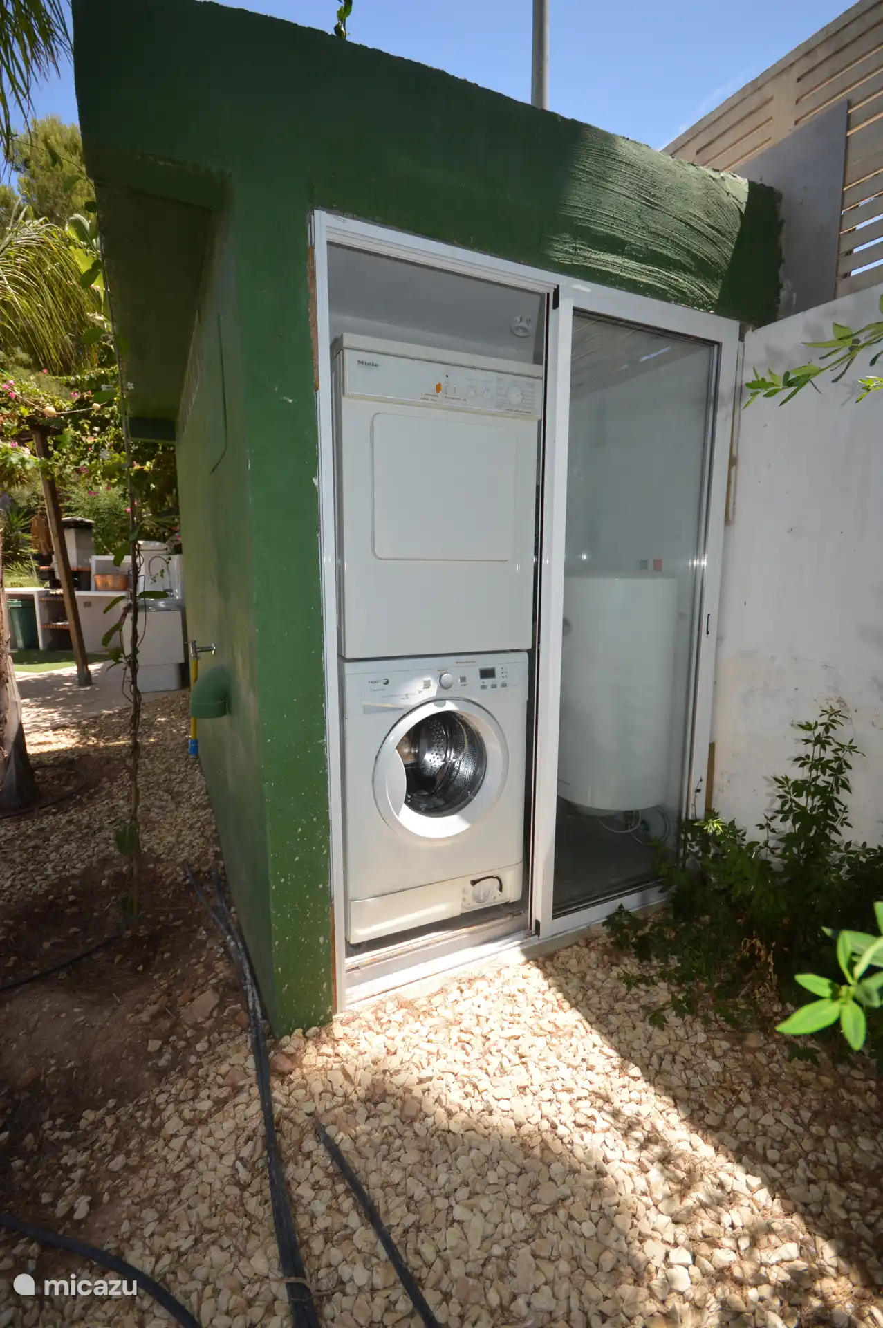 wasmachine en droger, naast de bbq ruimte en buitenbadkamer