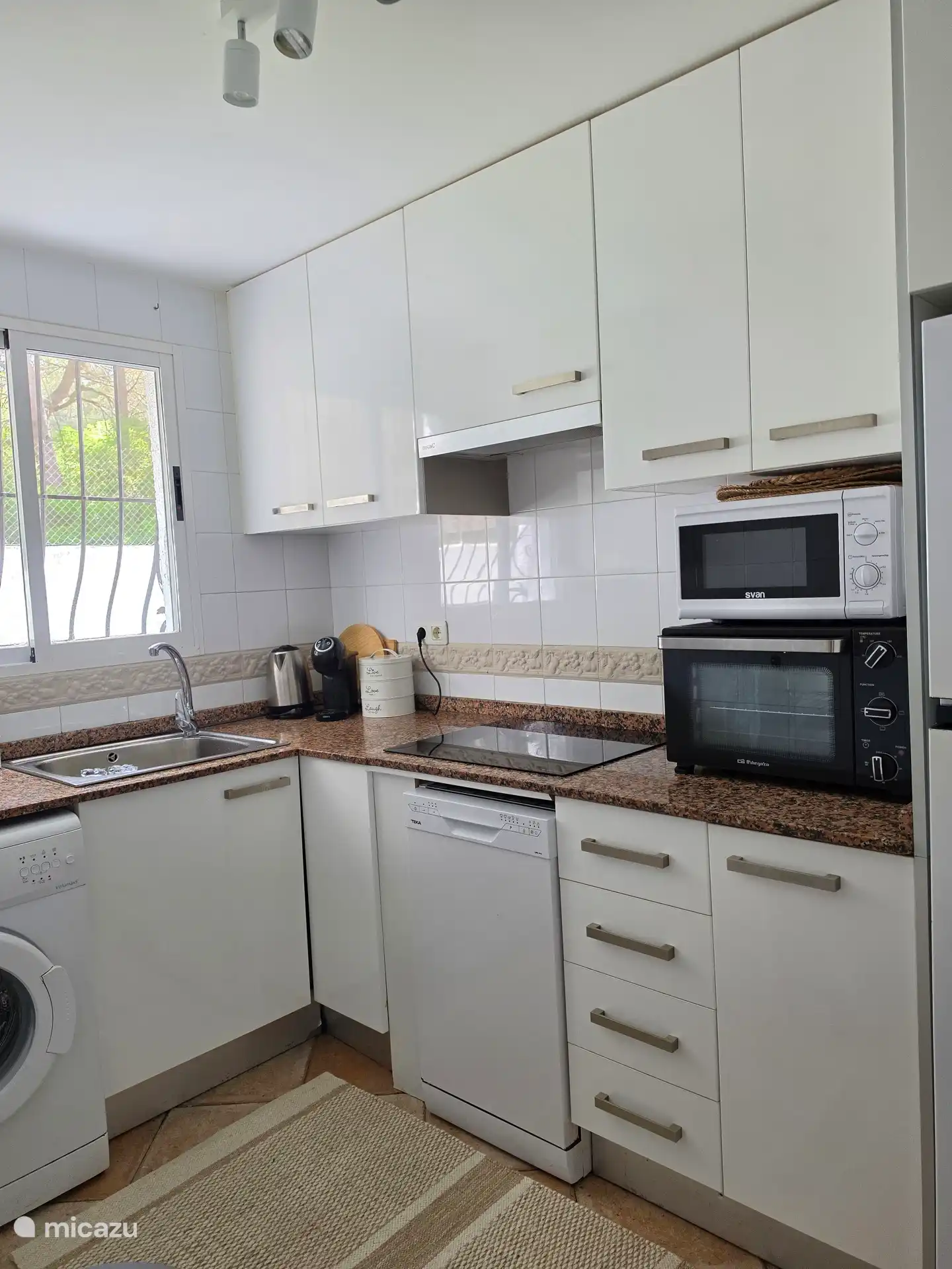 Keuken compleet, voorzien van koffiemachine, waterkoker, oven, magnetron, vaatwasser, wasmachine en koelkast met vriesvak.