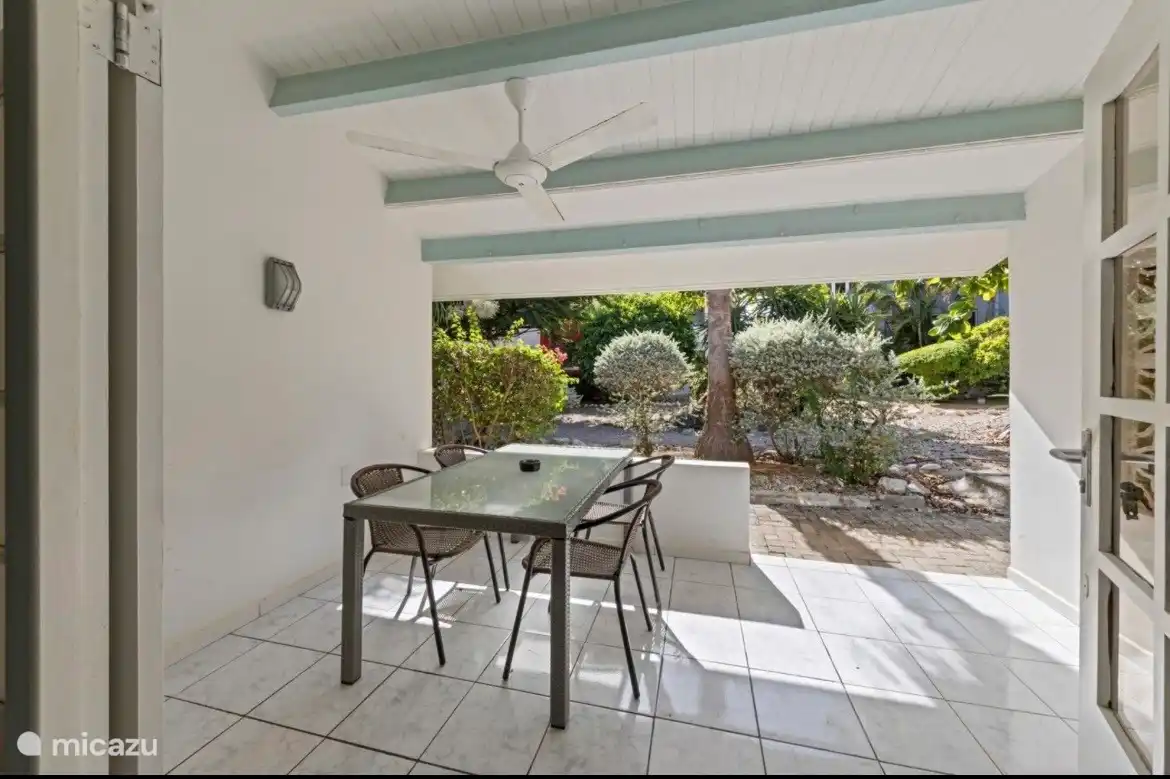 Het terras, een fijne plek om te ontbijten en in de avond een drankje te doen, met op de achtergrond de mooie tuin