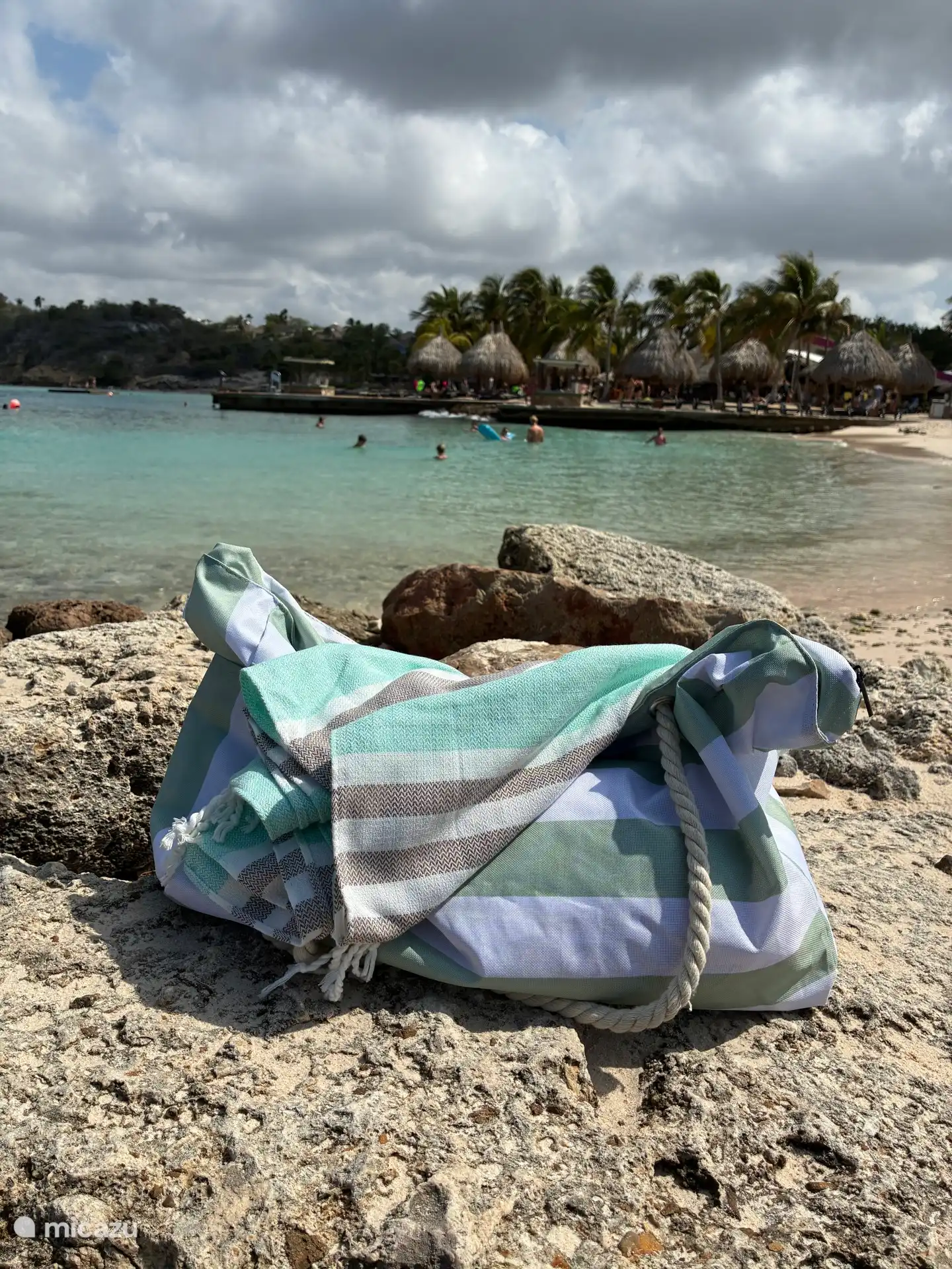 De strandtas en strandlakens waar u gebruik van kunt maken