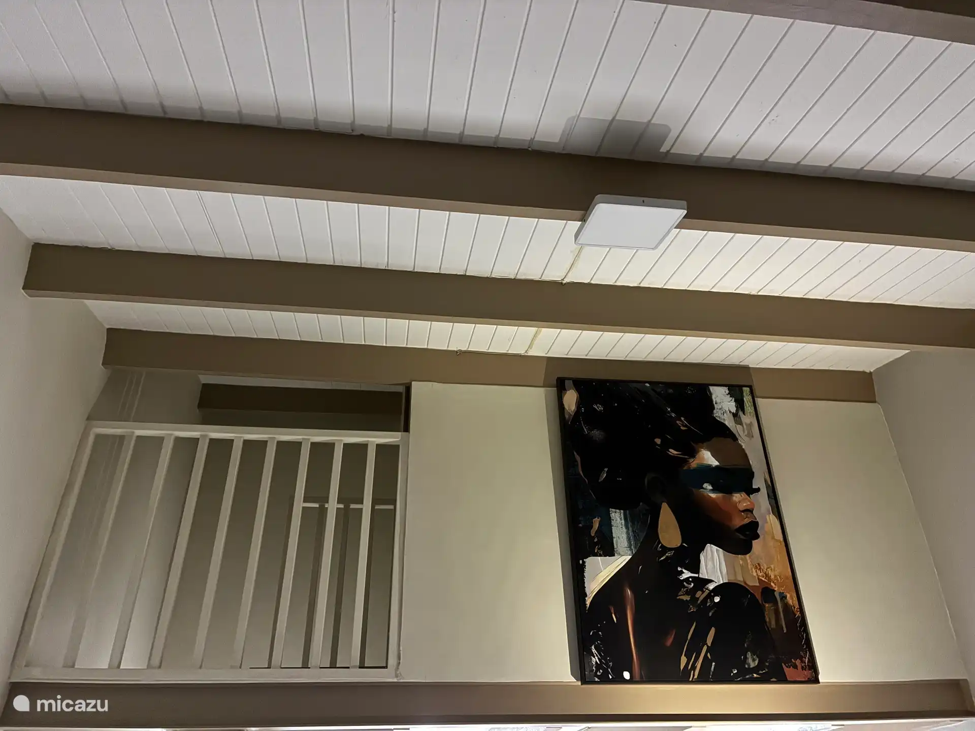 Zicht vanuit de woonkamer op de vide waar de slaapkamer is