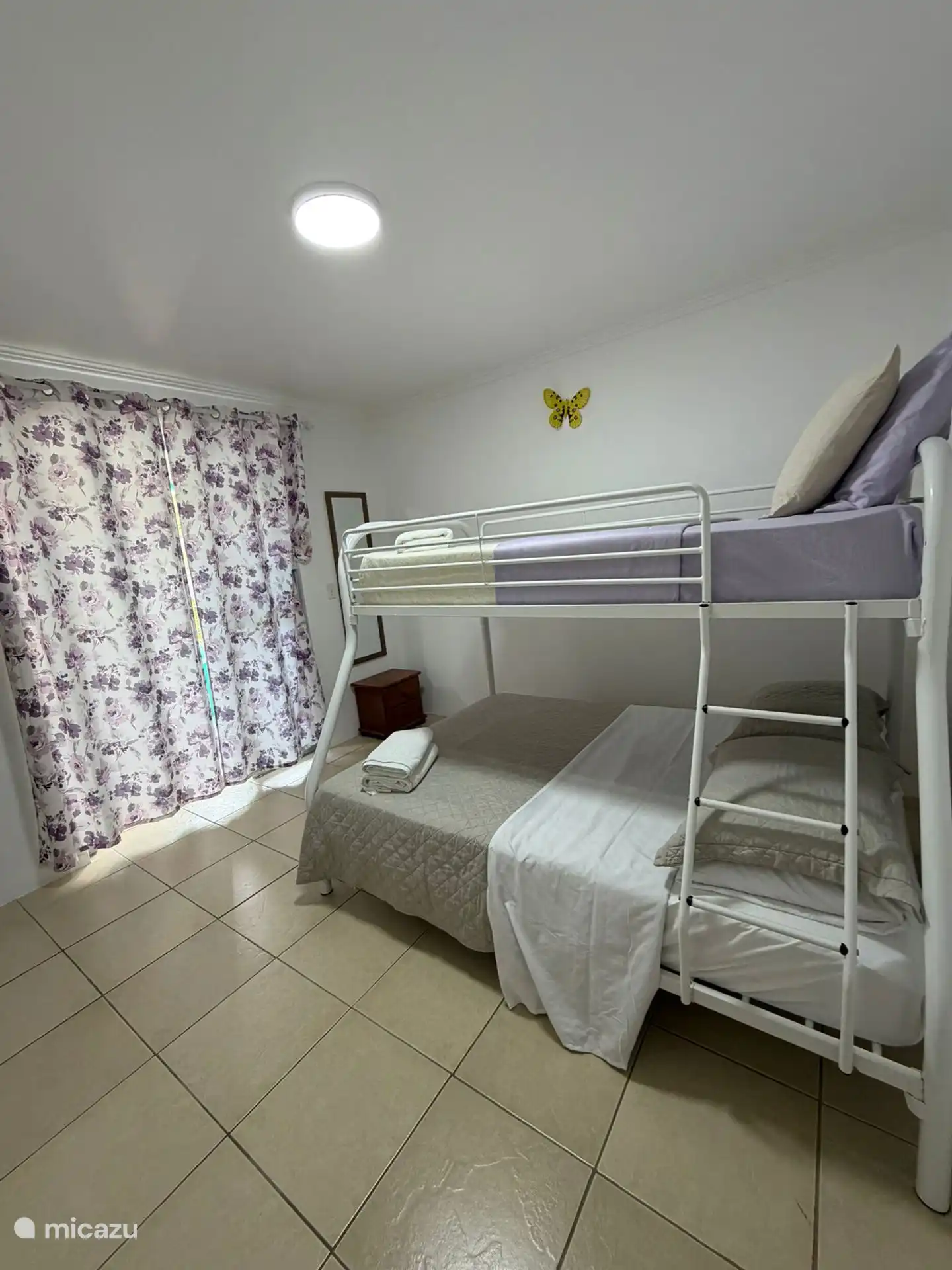 Schlafzimmer mit Etagenbetten und Nachttisch mit Spiegel