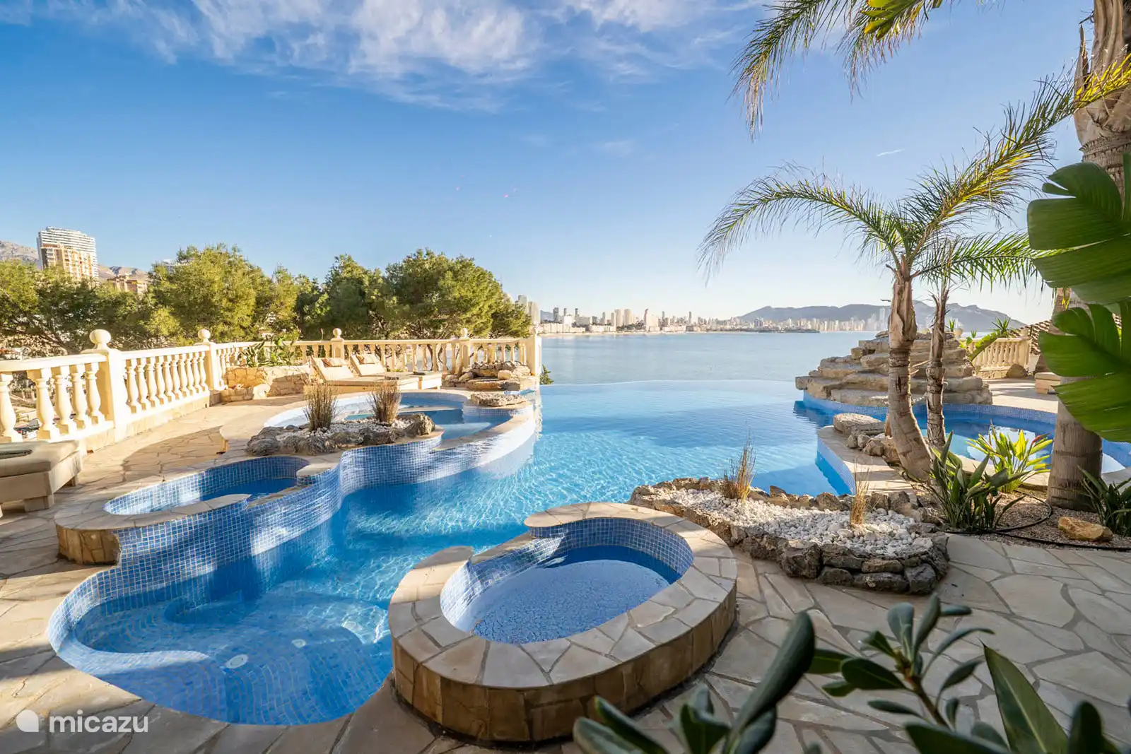 Infinity-Pool, Jacuzzi, Planschbecken, Brunnen, umgeben von einer Terrasse mit Liegeliege, Sofas. Speisesaal, Grill, Meerblick.