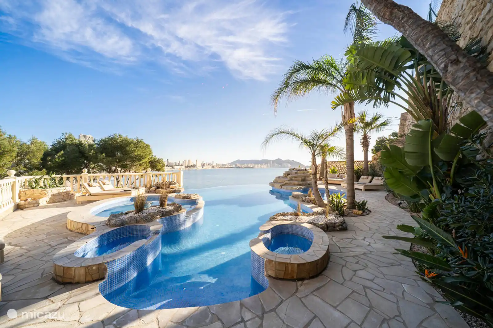 Infinity-Pool, Jacuzzi, Planschbecken, Brunnen, umgeben von einer Terrasse mit Liegeliege, Sofas. Speisesaal, Grill, Meerblick.