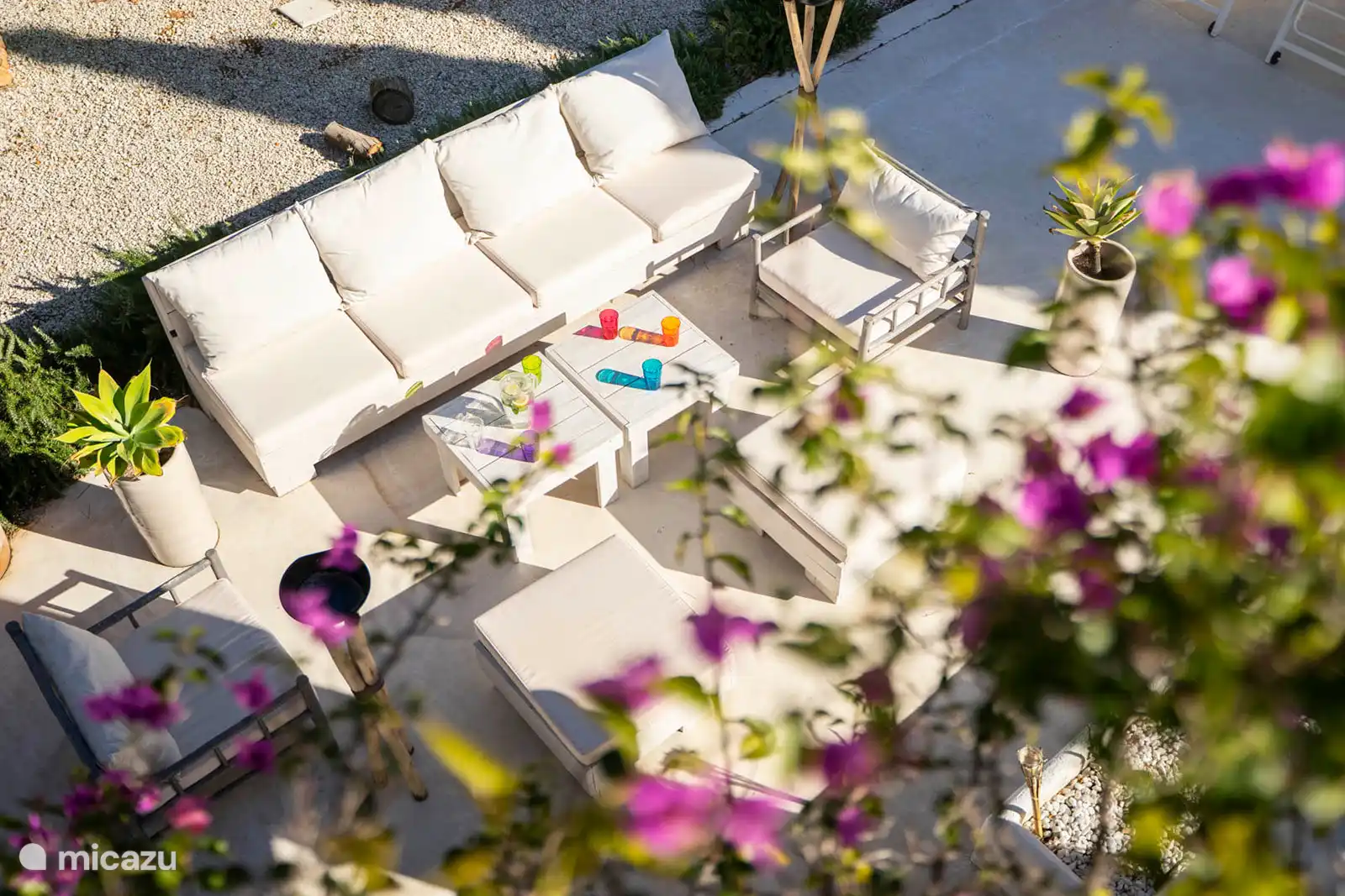 Swimming pool surrounded by a terrace with sun loungers, garden with trees, nature and mountain views, outdoor lounge.