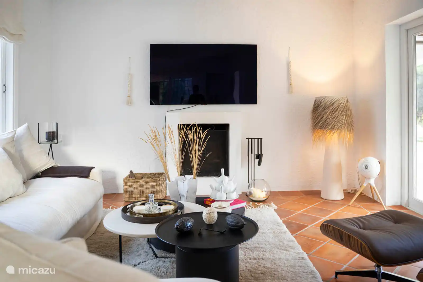 Living room with sofas, TV, air conditioning, terrace access.