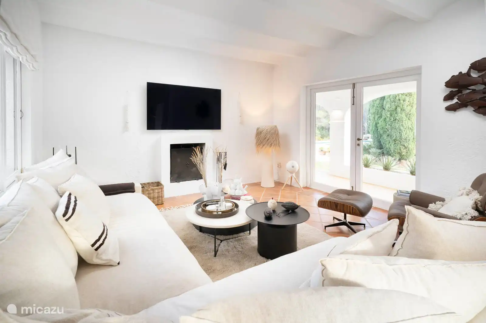 Living room with sofas, TV, air conditioning, terrace access.