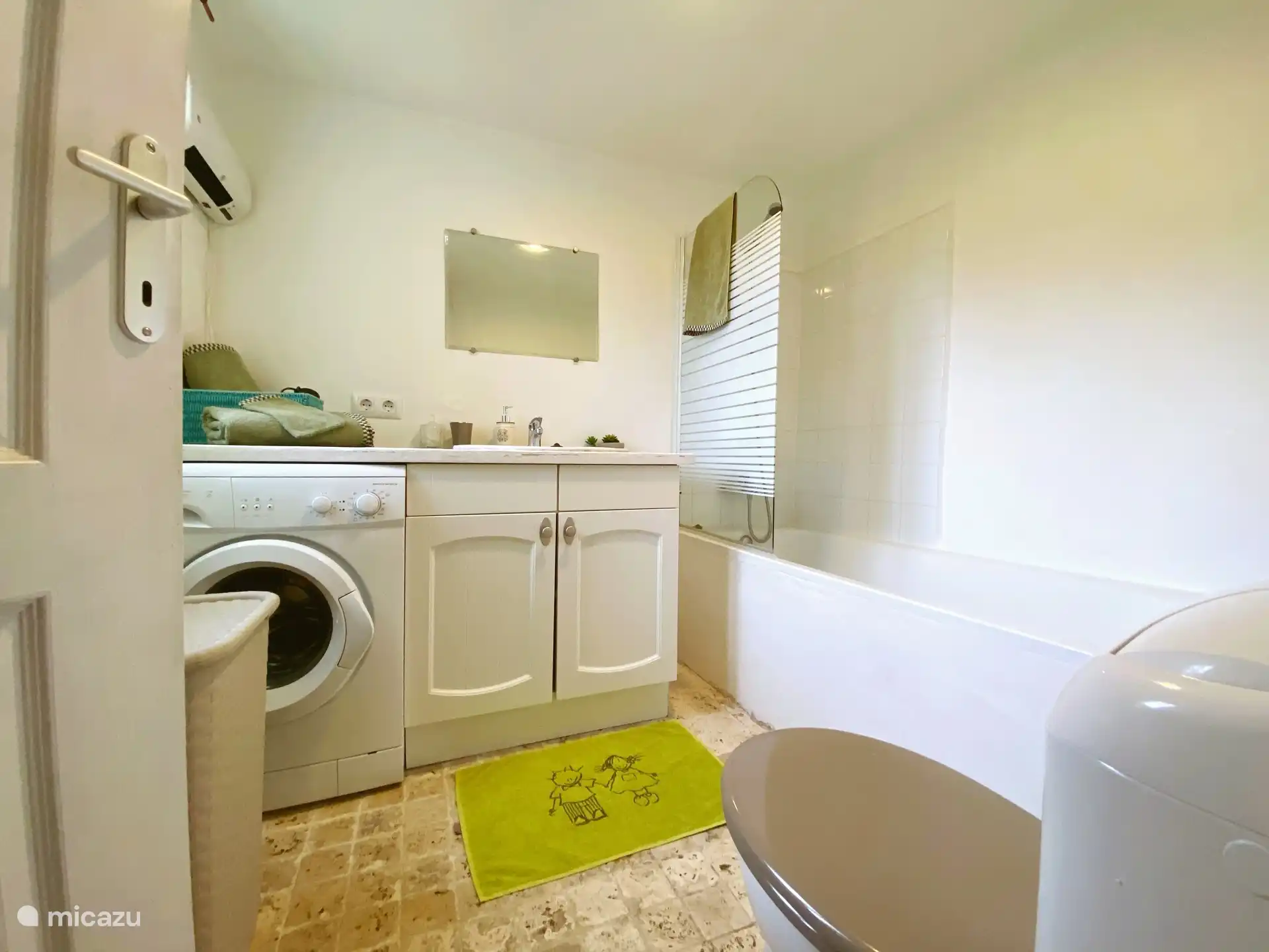 Baño en la planta baja con bañera y lavadora