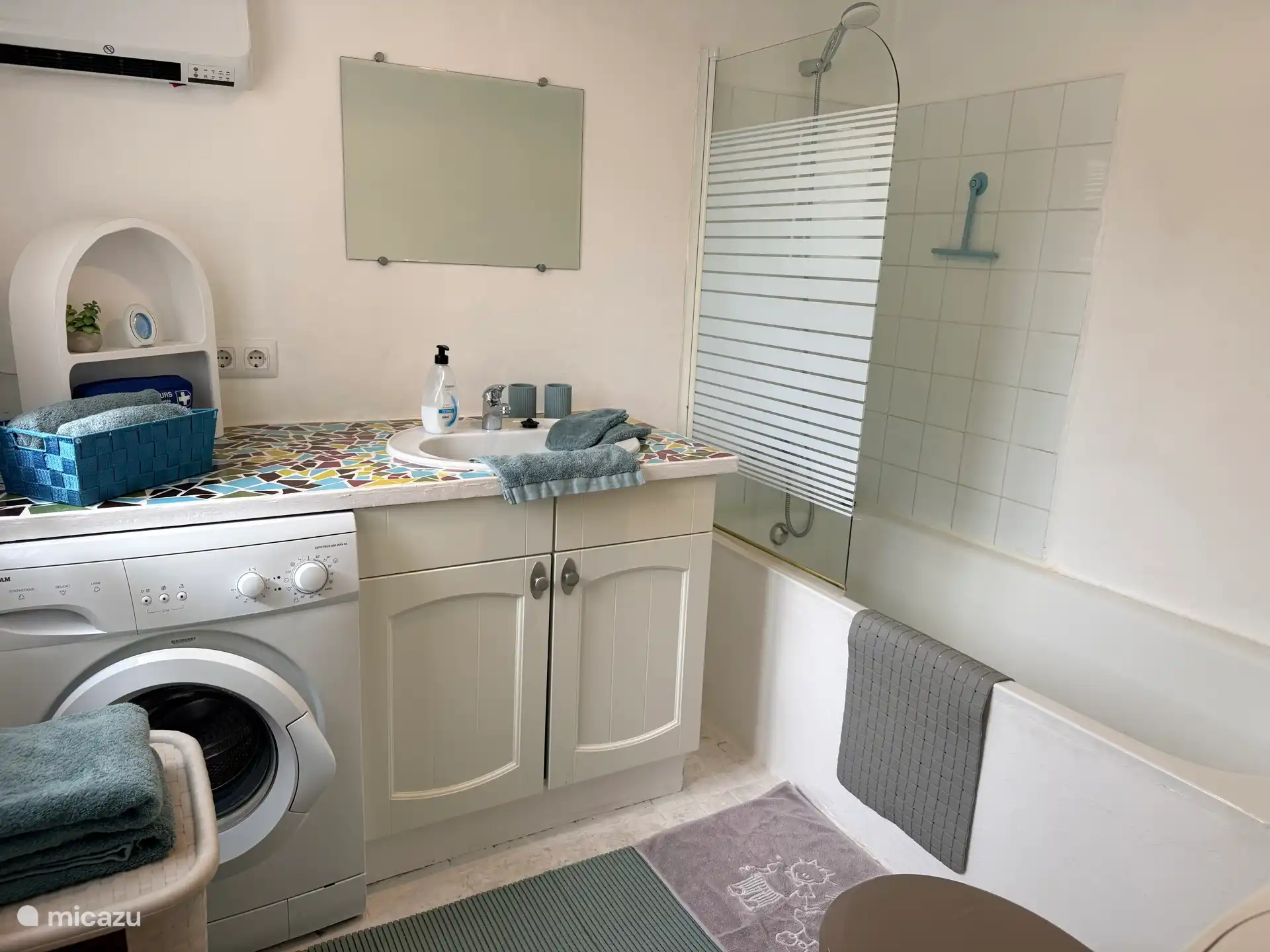 Badkamer met ligbad en douche en ook wasmachine