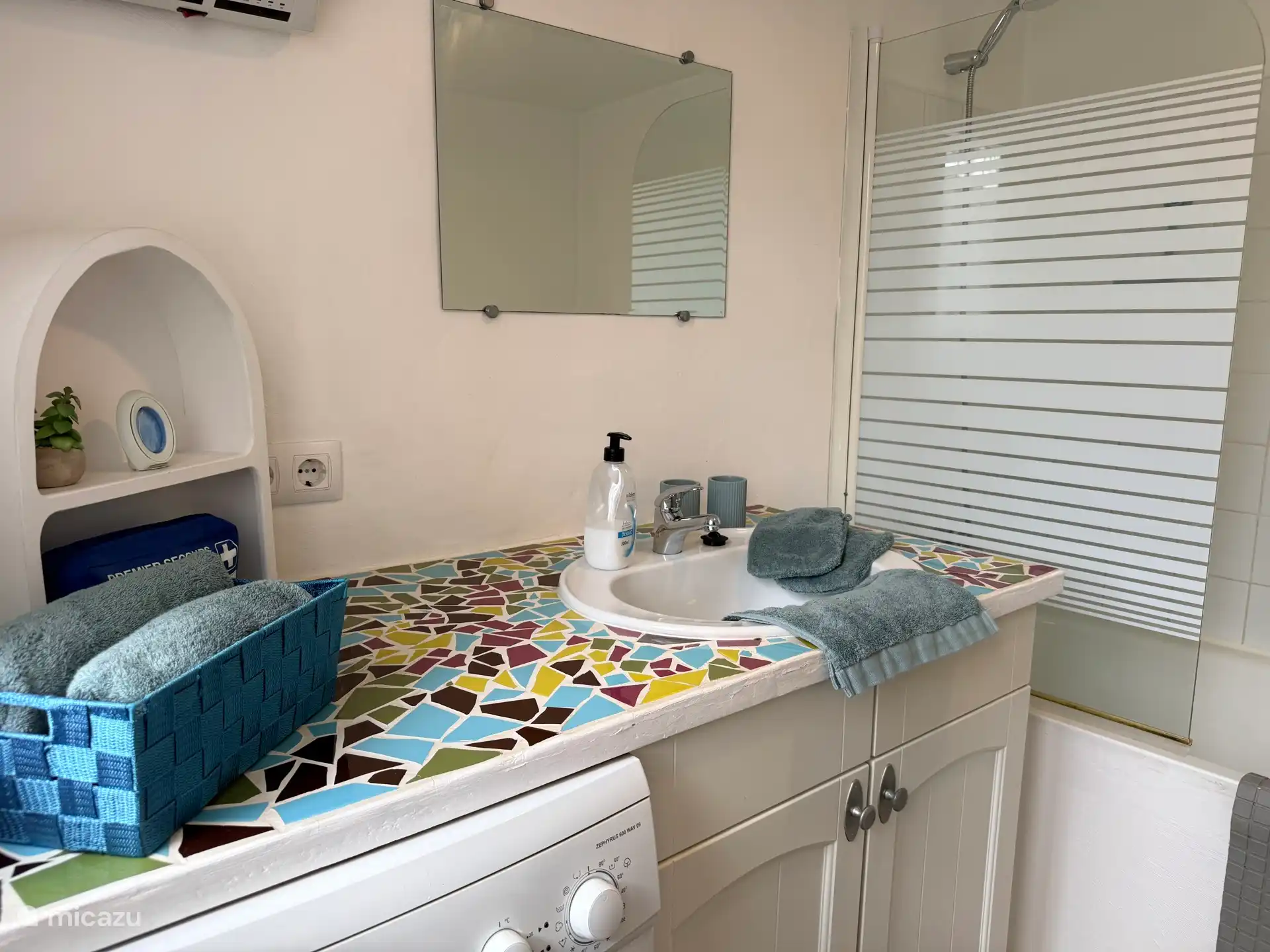 Badkamer met ligbad en douche en ook wasmachine