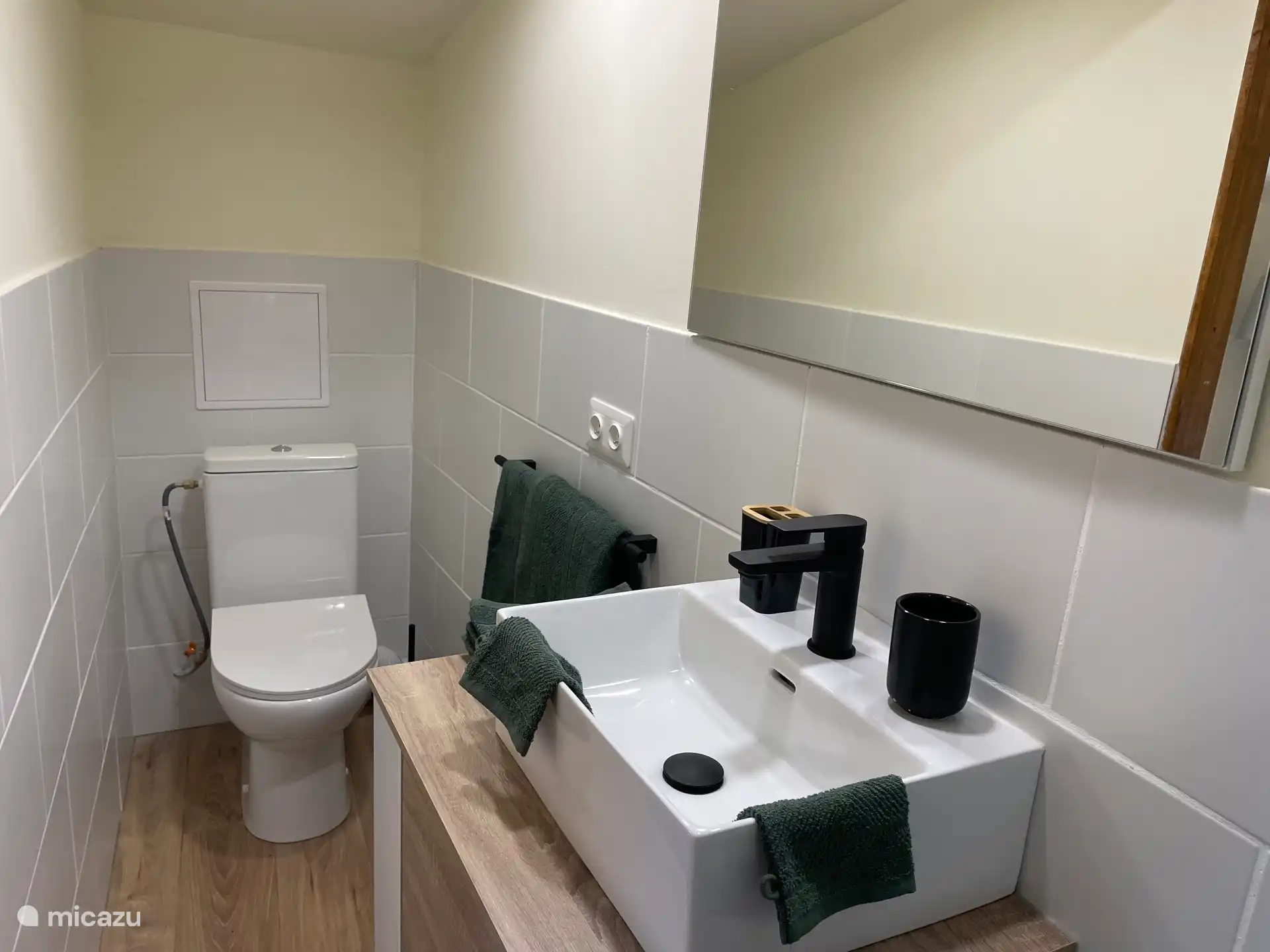 Baño cómodo con inodoro y ducha espaciosa. El baño está conectado por una puerta corredera al dormitorio. Todo comodidad.