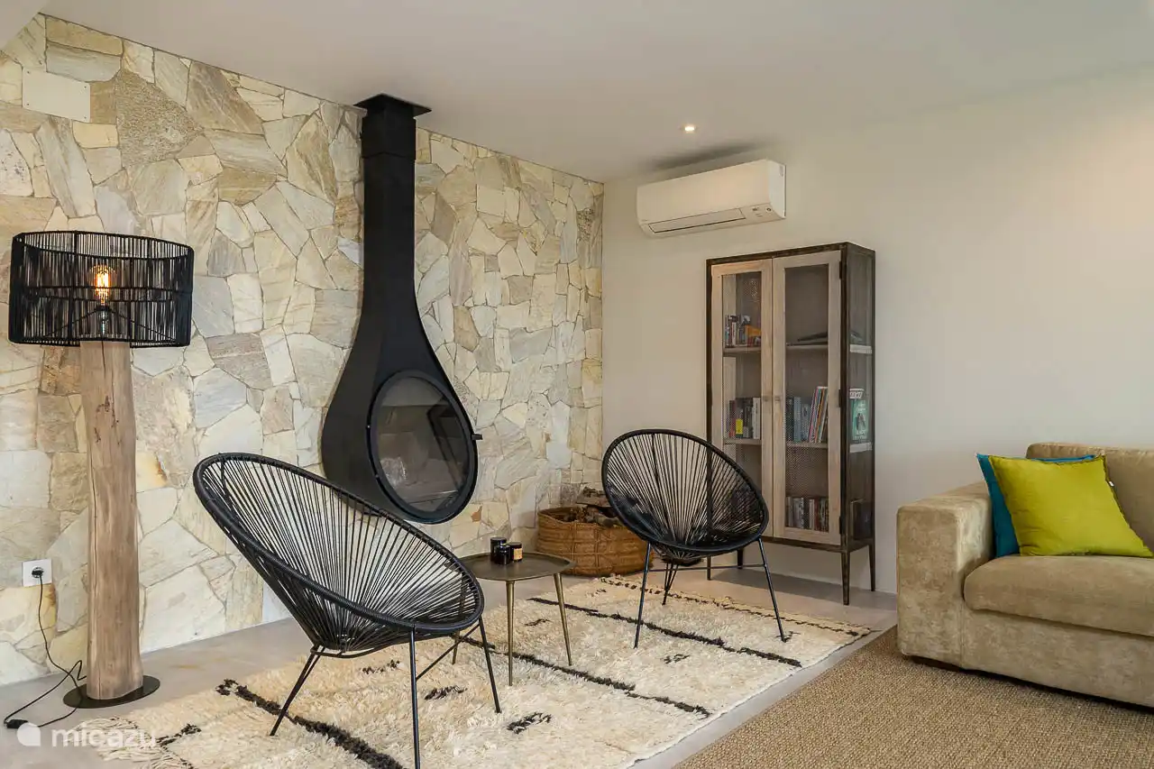 Salon avec canapés, TV, climatisation, accès terrasse.