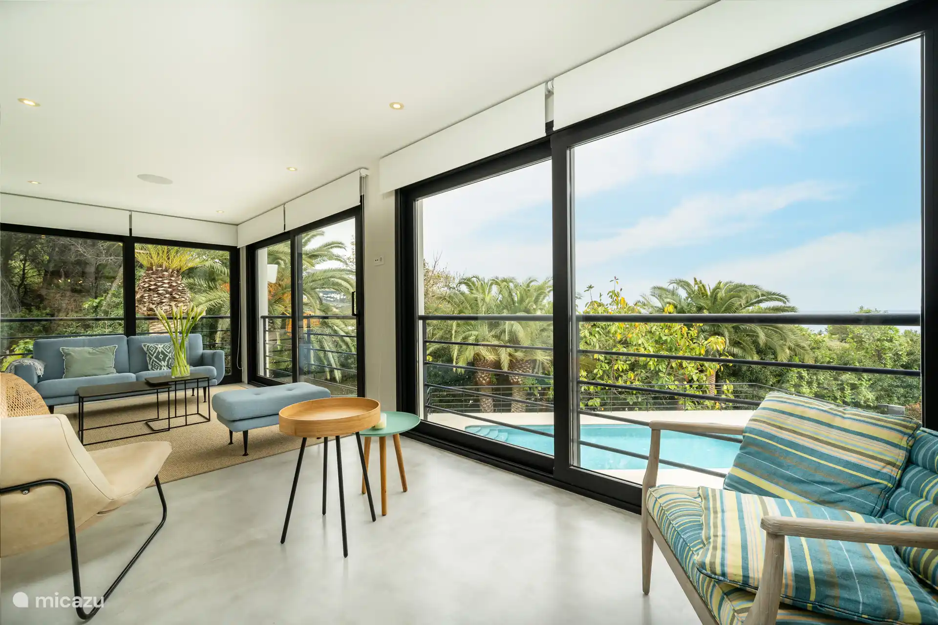 Salon avec canapés, TV, climatisation, accès terrasse.