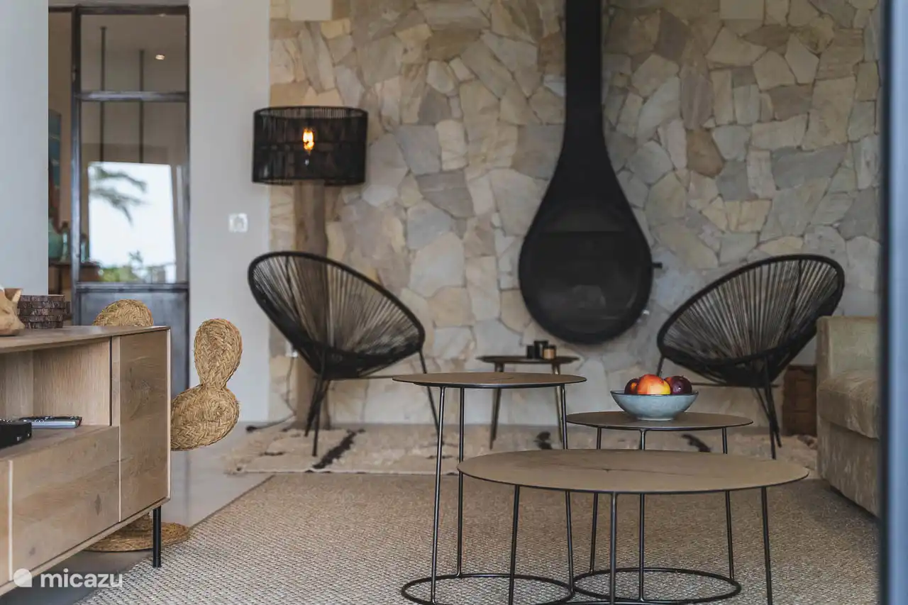 Salon avec canapés, TV, climatisation, accès terrasse.