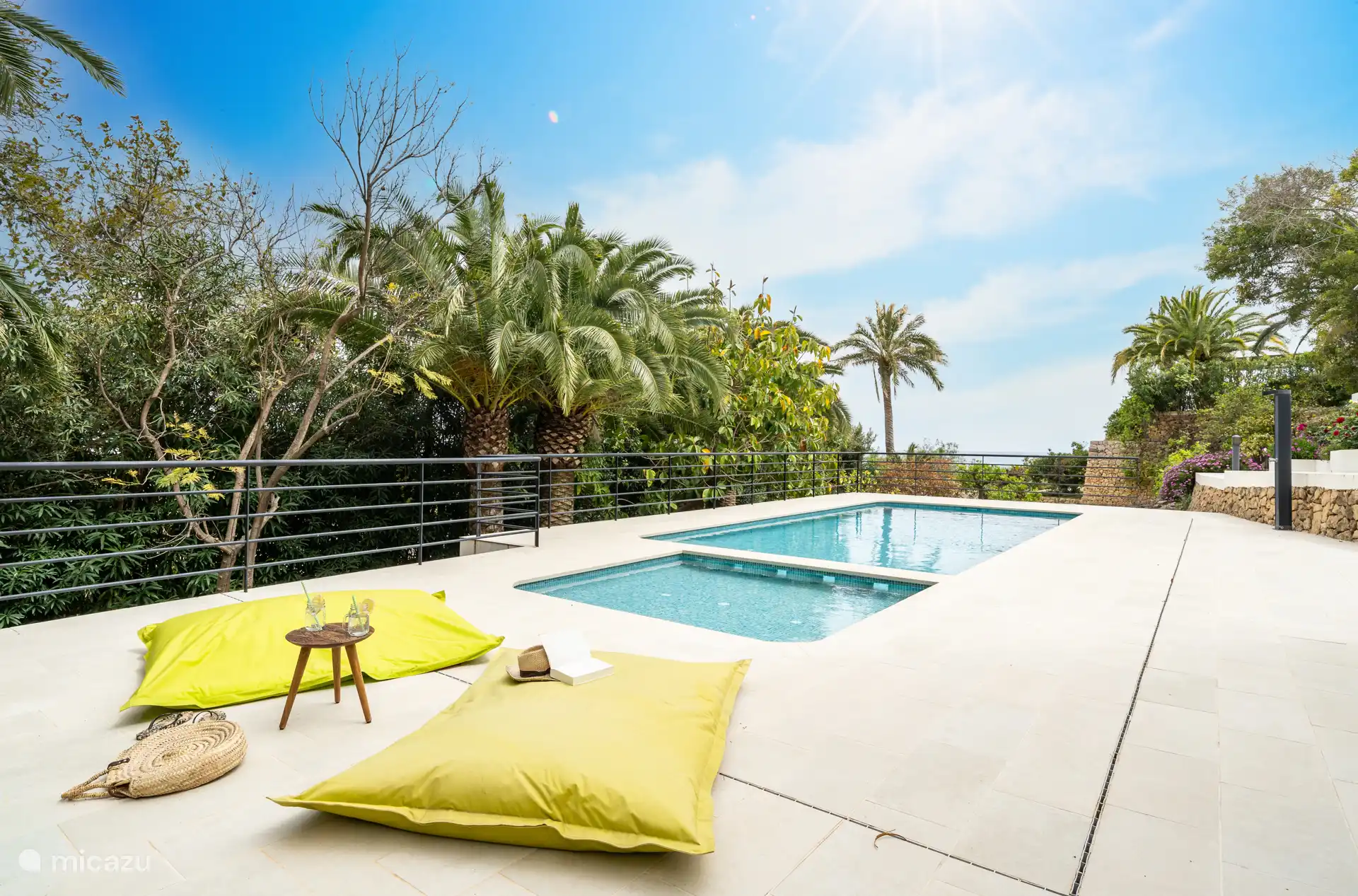 Piscine entourée d'une terrasse avec chaises longues.