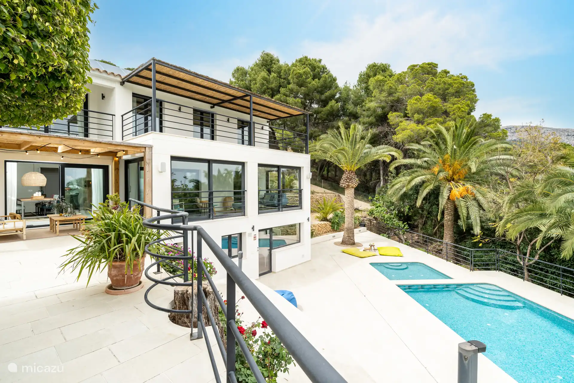 Piscine entourée d'une terrasse avec chaises longues jardin arboré, vue sur la mer, salon extérieur, salle à manger, barbecue.