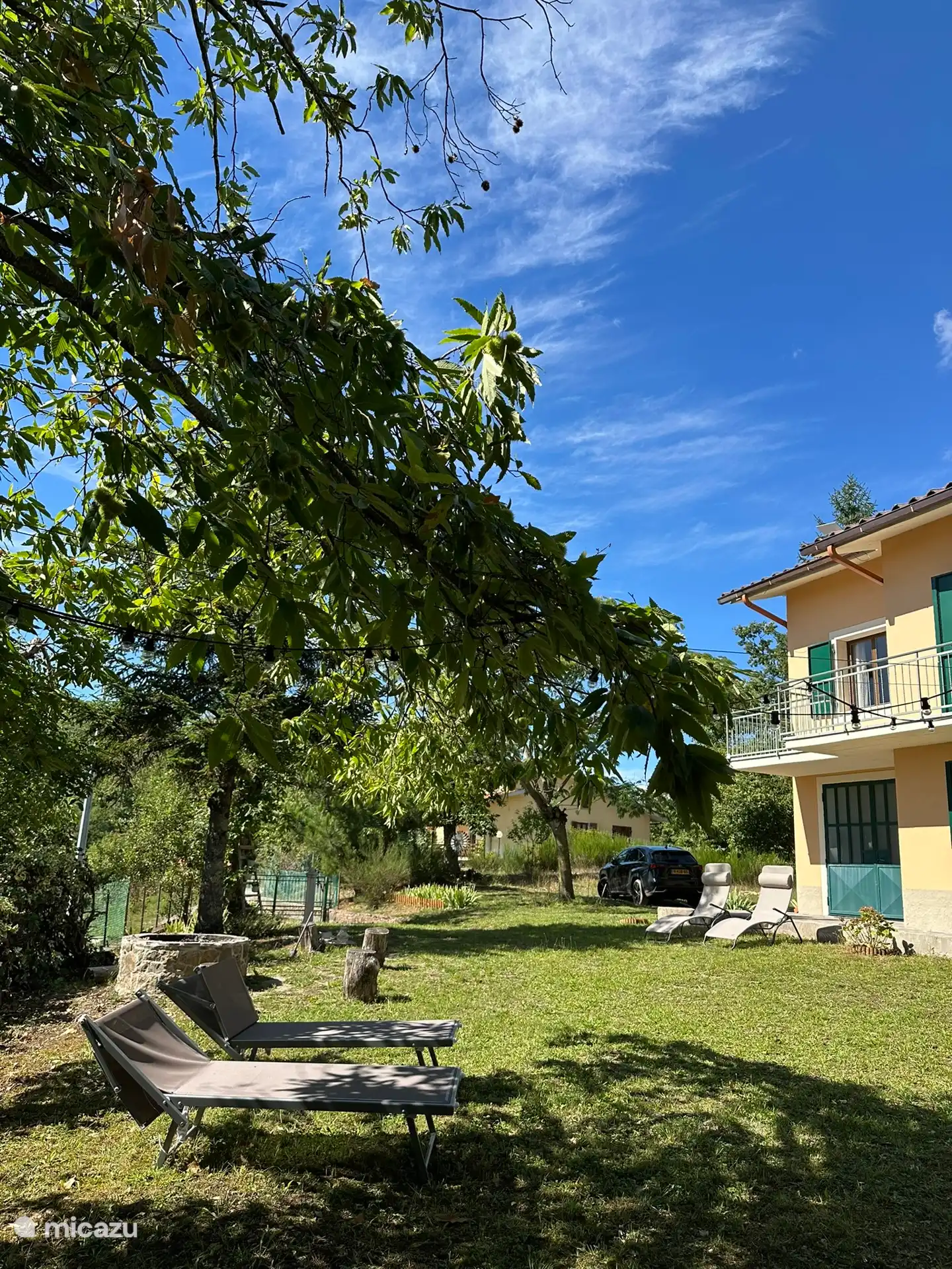 Jardin avant avec vue sur l’entrée et le parking.