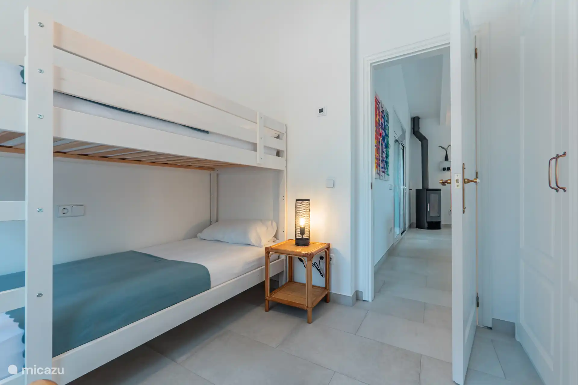 Stapelbed met uitzicht op een open woonkamer