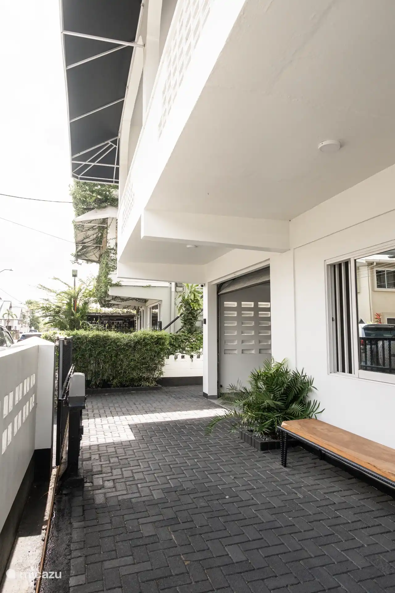 voortuin met bankje, electrische poort en garage