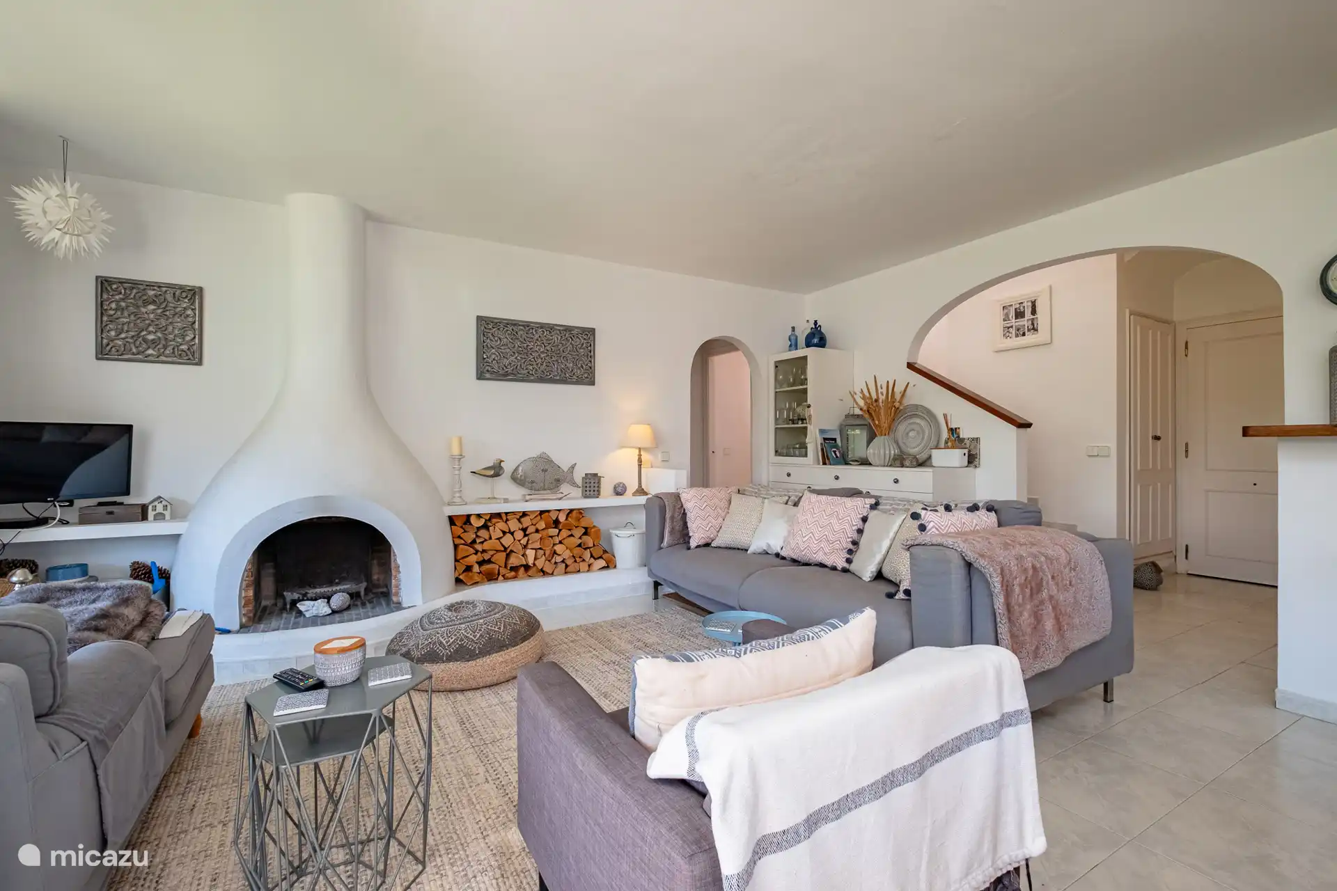 Ingang en zitkamer, die leiden naar de onderste slaapkamer en trappen naar de bovenverdieping. 