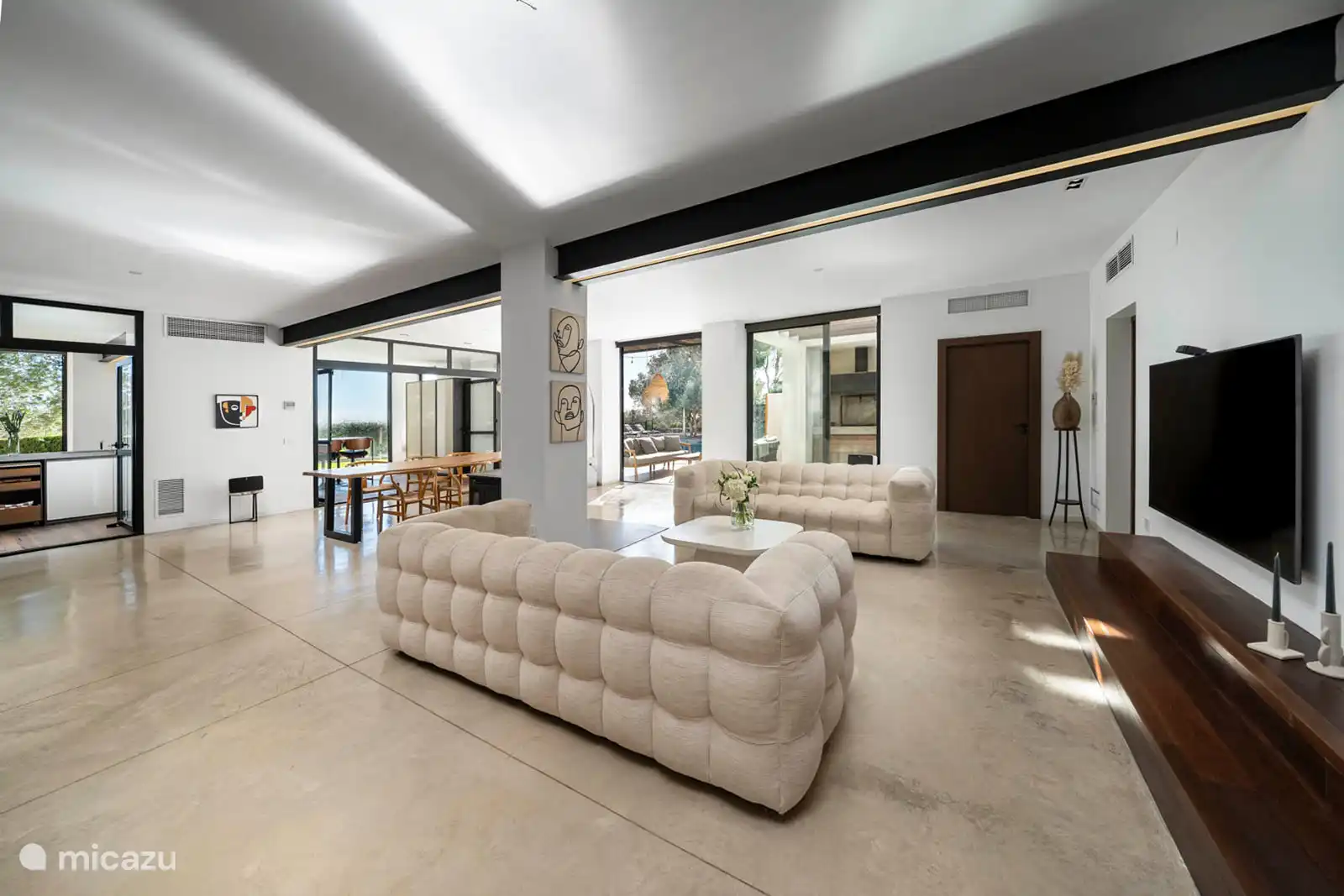 Woonkamer met banken, eetkamer, bodega, tv, airconditioning, toegang tot het terras.