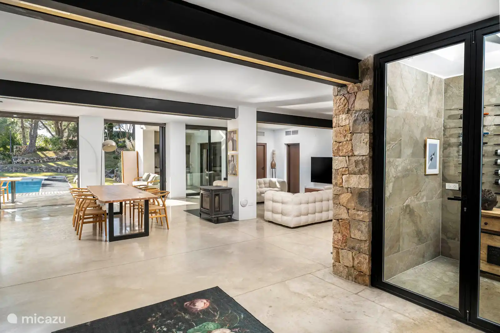 Woonkamer met banken, bodega, tv, airconditioning, terrastoegang.