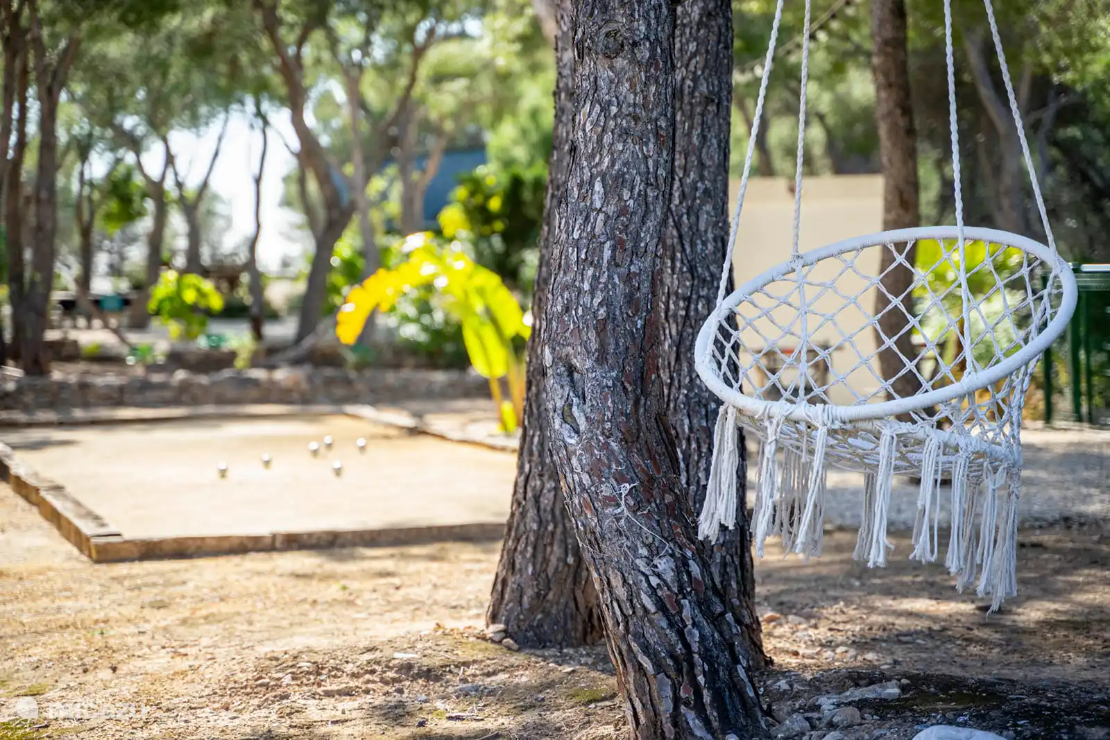 Een petanque-ruimte en een schommel maken deze feestelijke decoratie compleet, waar elk moment buiten rijmt op ontspanning, zon en de zoetheid van het leven.