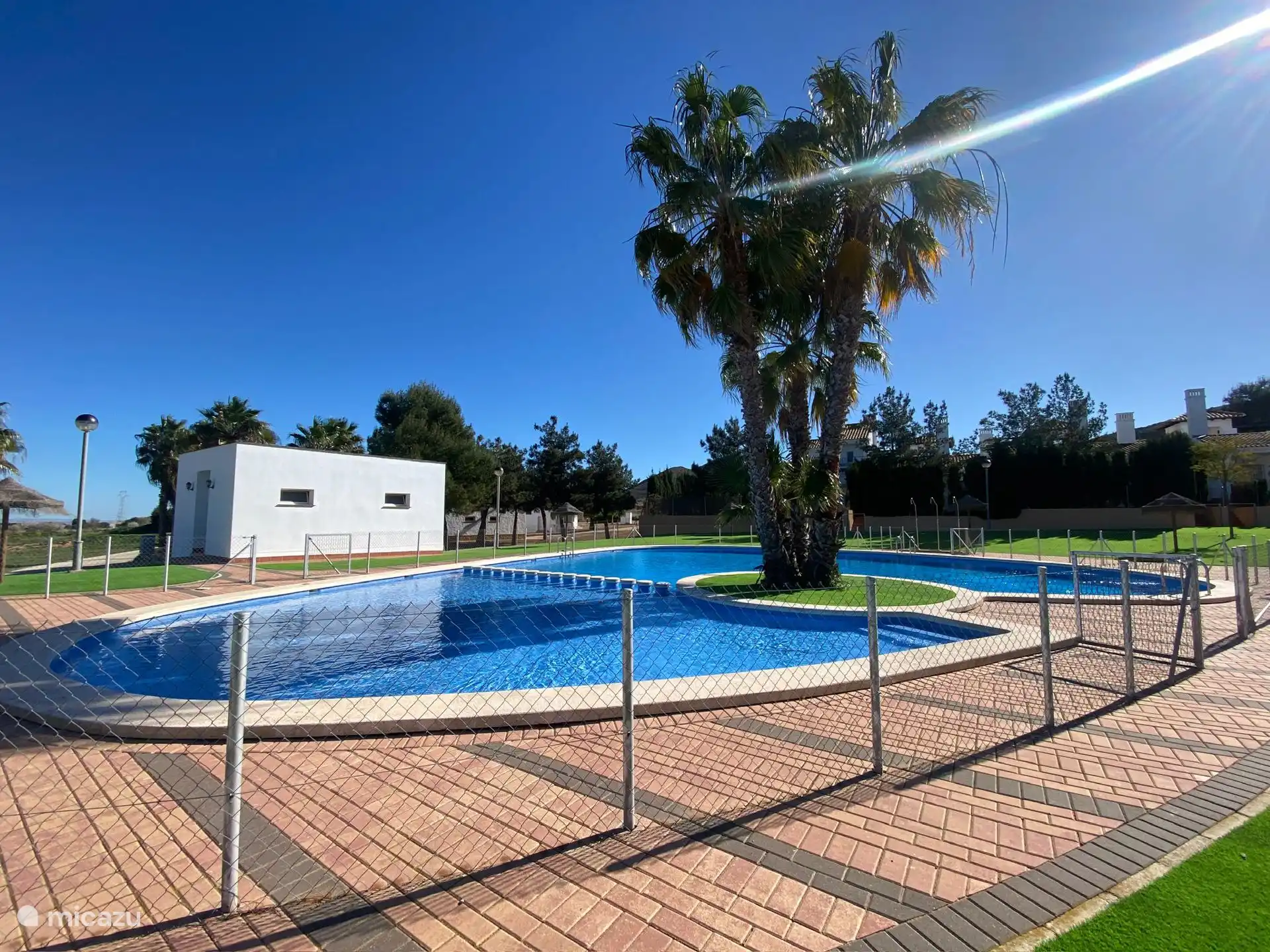 Piscina comunitaria con duchas, césped artificial y aseos
