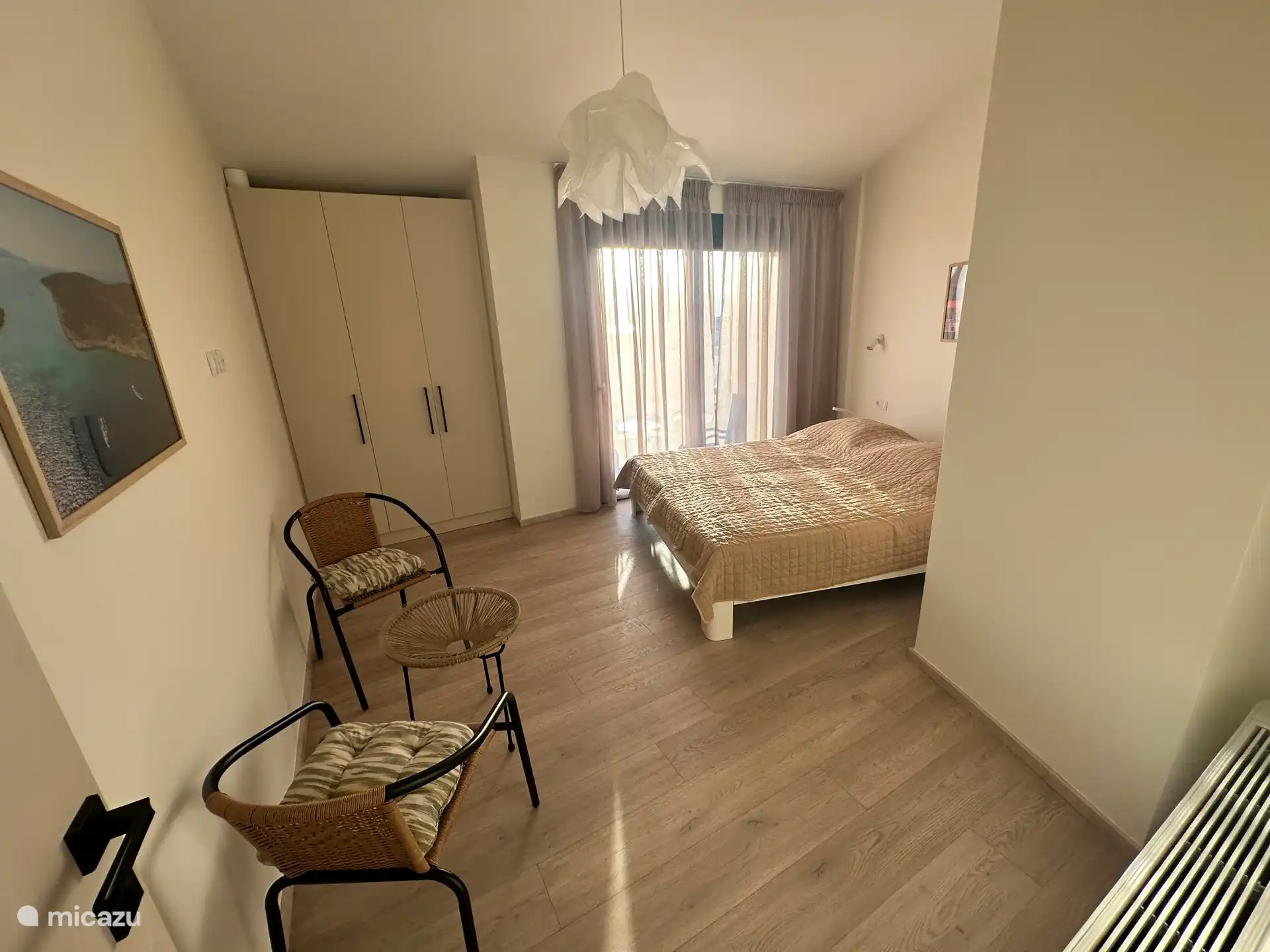 Bedroom 1 upstairs with King size bed, ample storage space, and a balcony over viewing the pool and the amazing views of the town and Ionian Sea