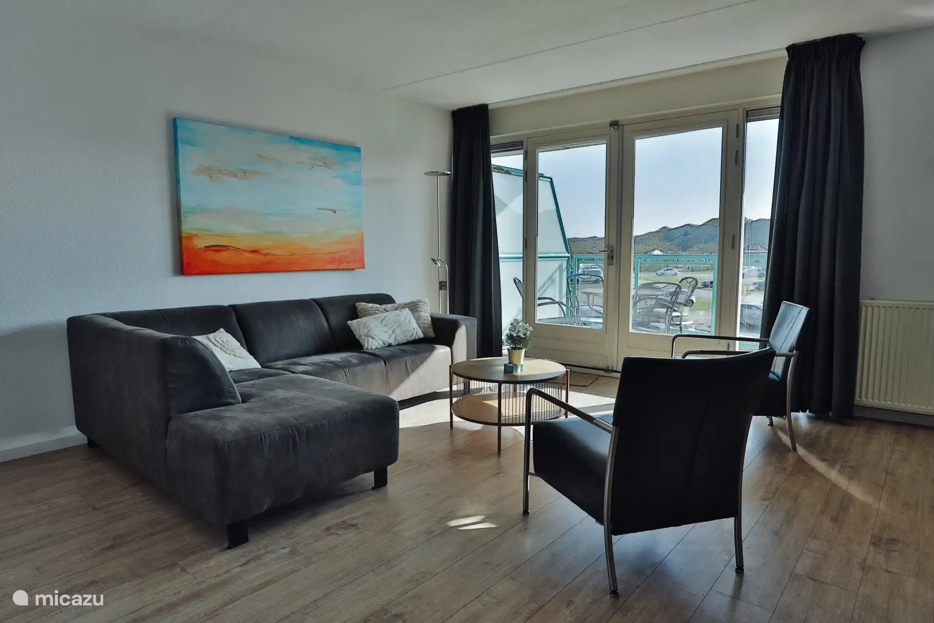 Salón con vistas a las dunas. Acceso al balcón con sol hasta tarde por la tarde.