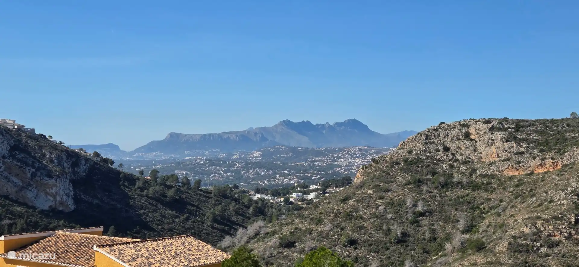 Uitzicht vanaf het balkon op Moraira en de bergketen Sierra de Bernia.