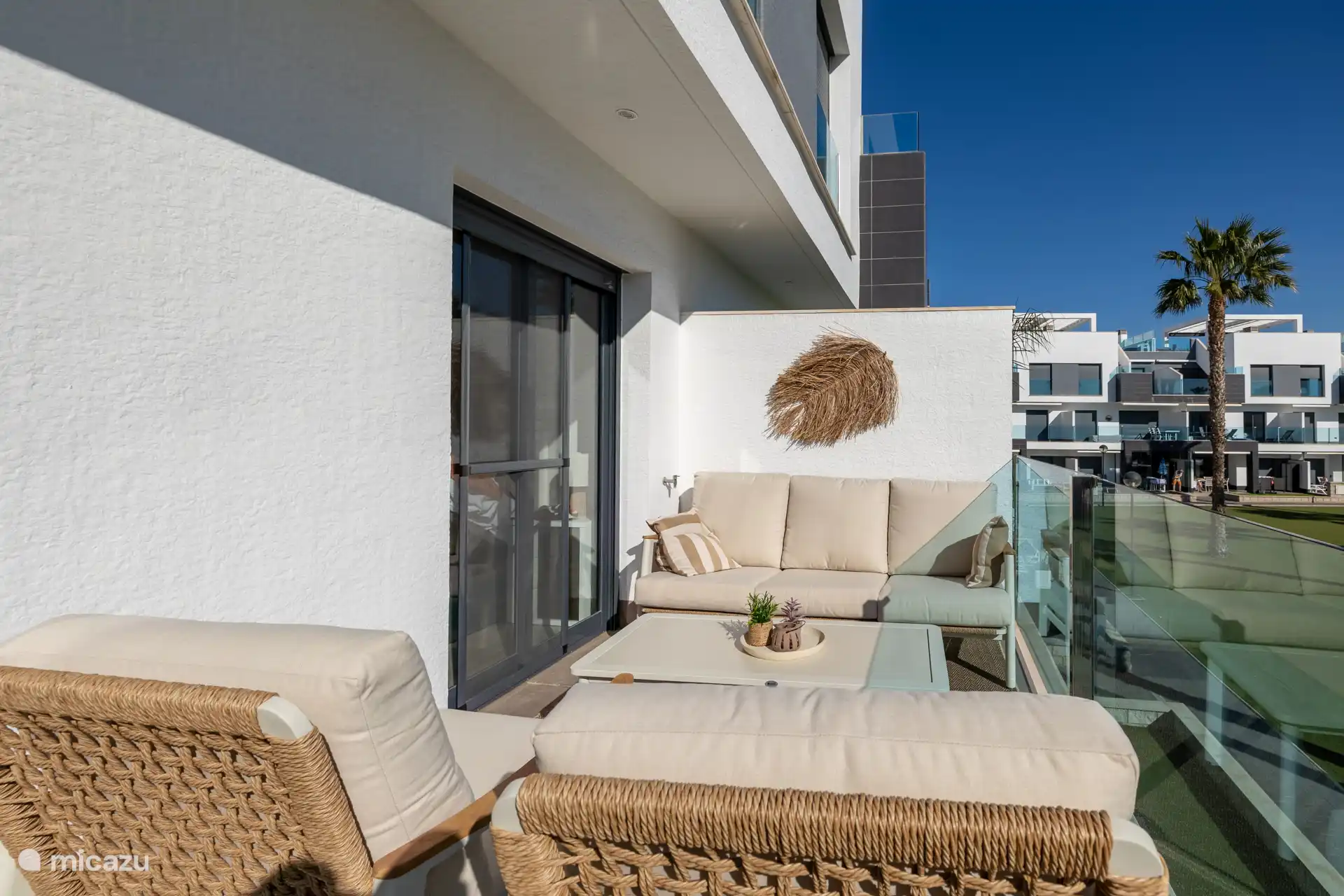 Le balcon dispose également d’un salon confortable et d’un fauteuil suspendu, d’où l’on profite d’une belle vue sur la piscine et on peut se détendre avec un livre ou un verre.