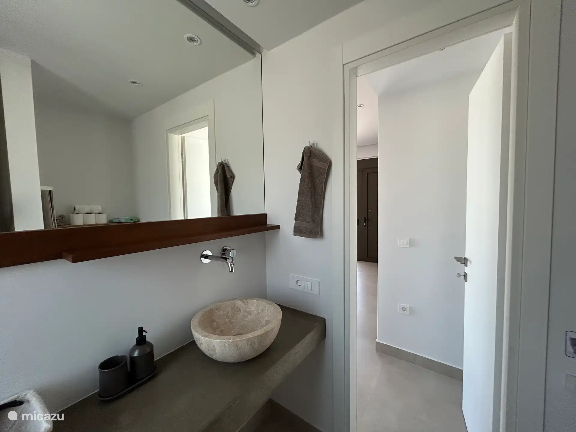 Waschbecken und großer Spiegel im kompletten Badezimmer 