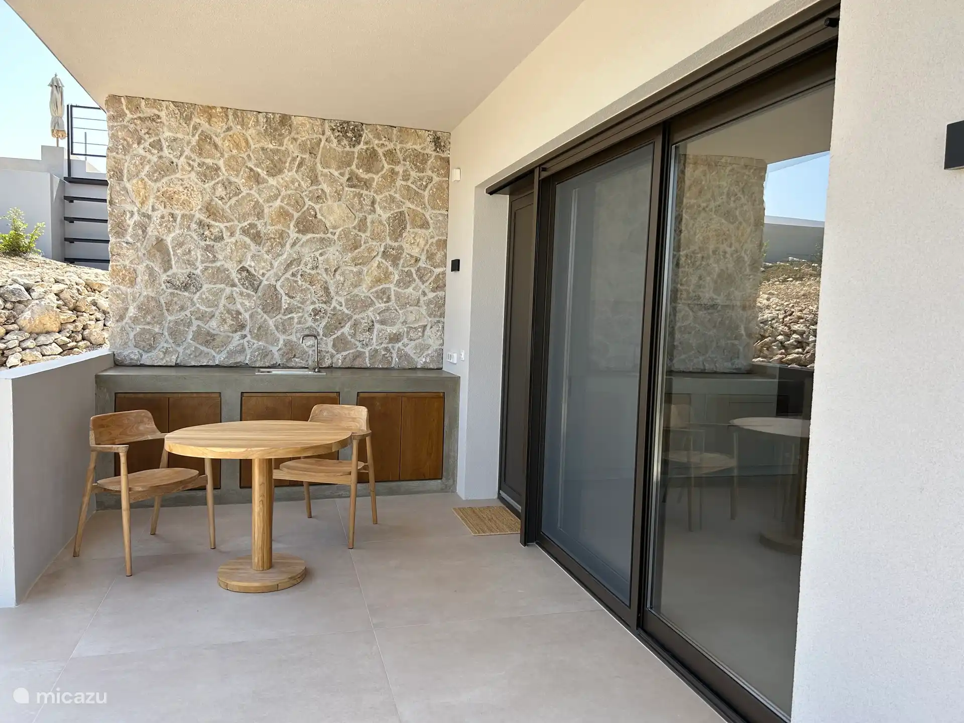 Terrasse mit Tisch und Stühlen sowie einem Außenwaschbecken 