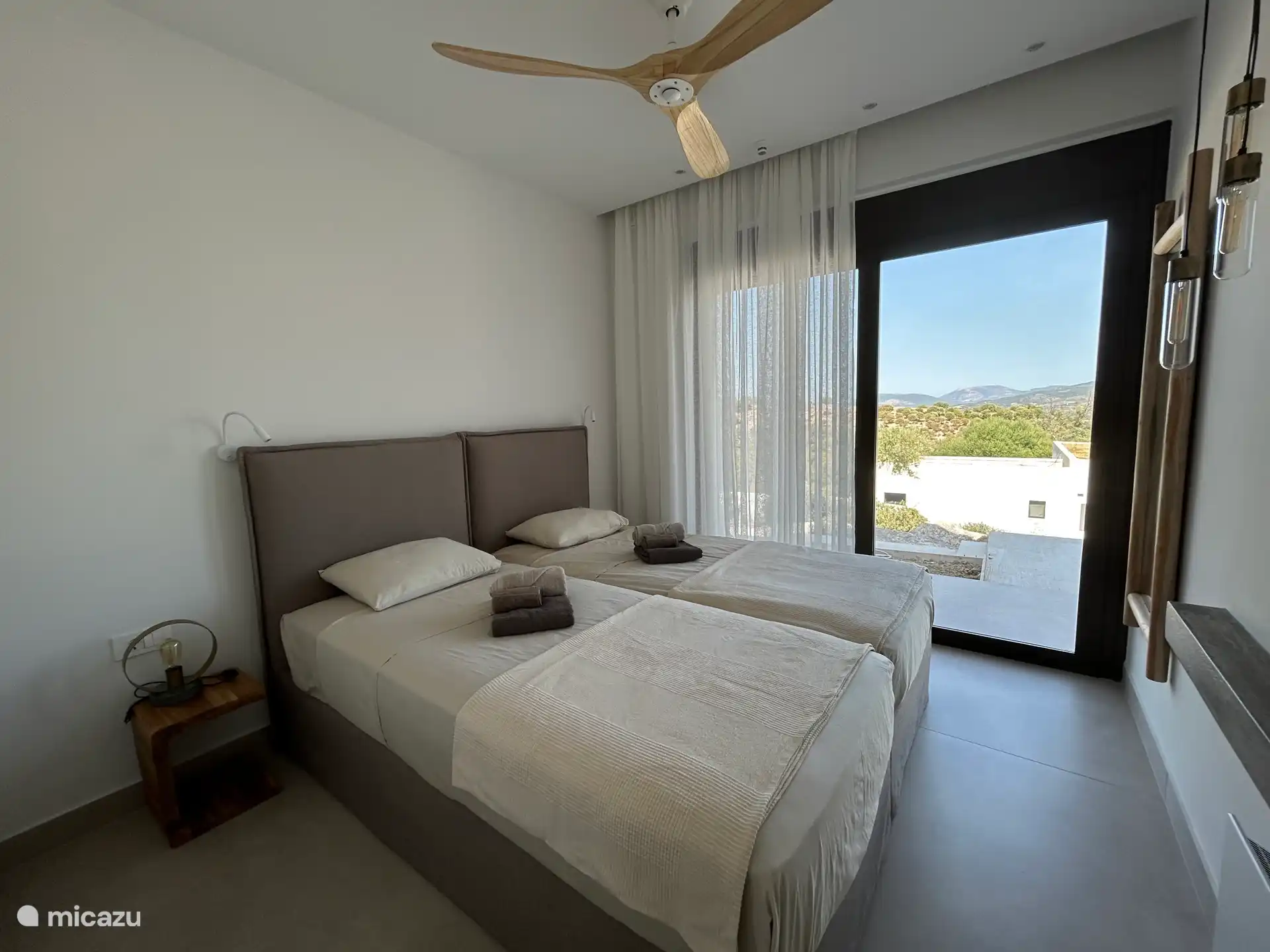 Schlafzimmer mit 2 Einzelbetten, Deckenventilator sowie Klimaanlage und ruhigem Blick auf die Natur 