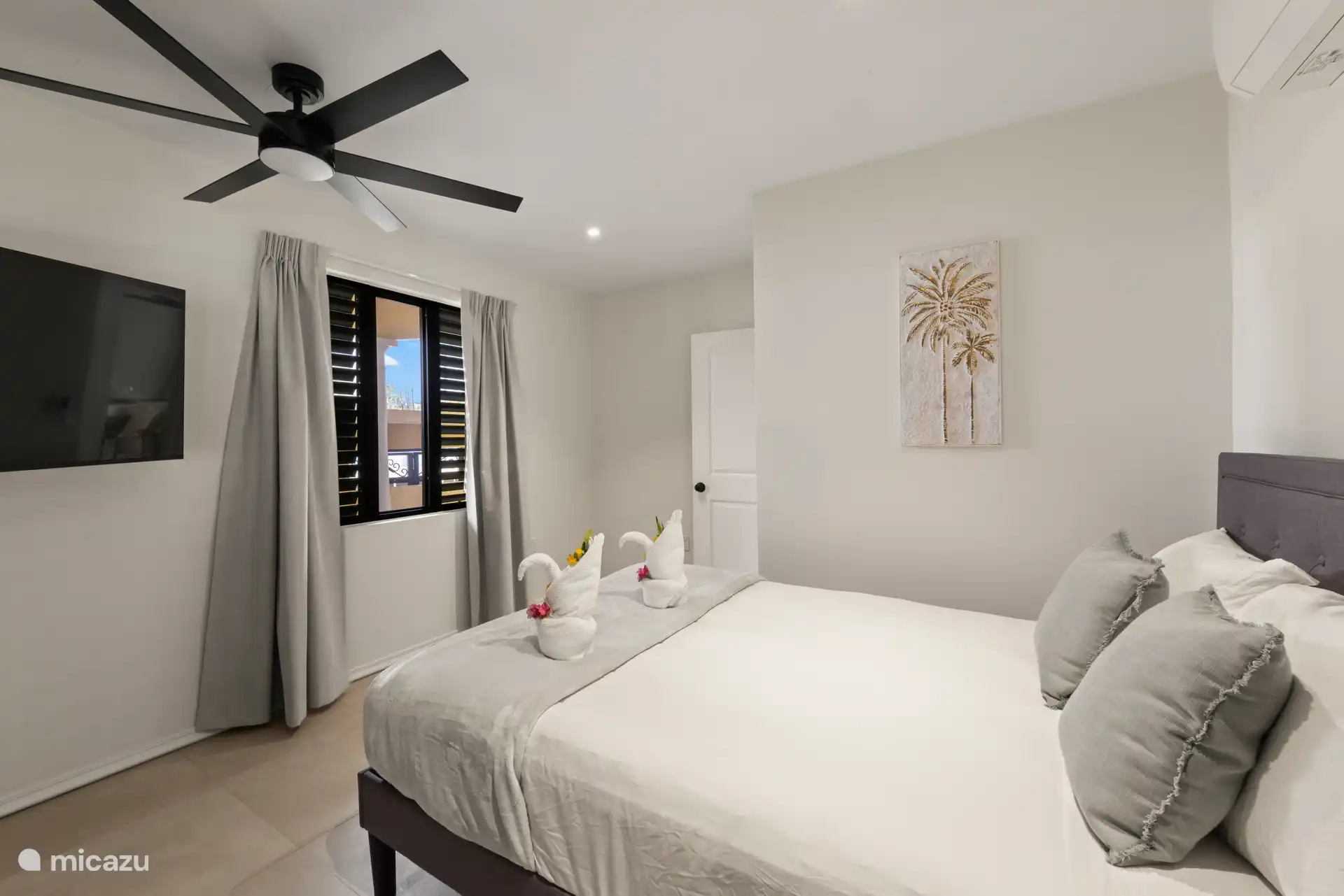 Dormitorio con televisor y mosquiteras en todas las ventanas, para dormir cómodamente por la noche.