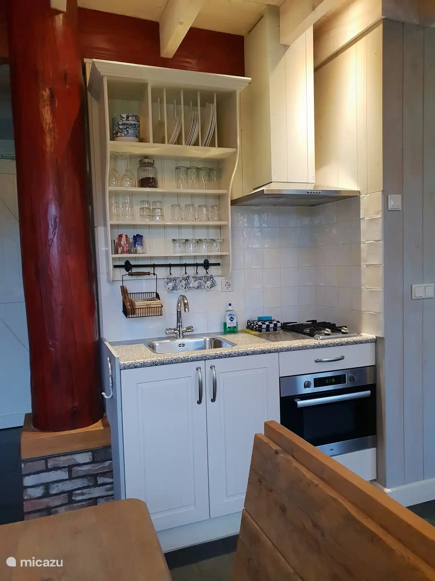 La cuisine, elle semble petite, mais en face de cette unité de cuisine se trouve un bloc avec le réfrigérateur, la cafetière et la bouilloire. Un réchaud à deux feux et plein d’ustensiles de cuisine et de vaisselle.