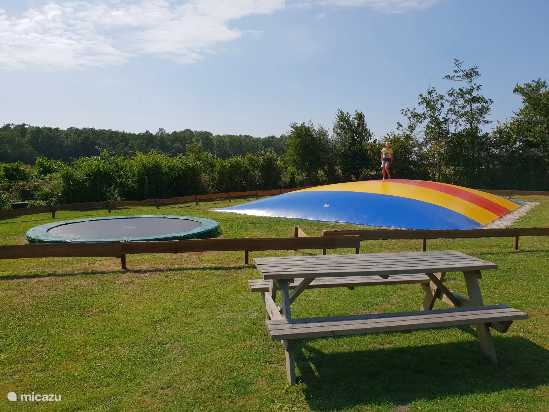 Château gonflable, trampoline et terrain de football. Beaucoup d’espace dehors pour jouer et se rencontrer.