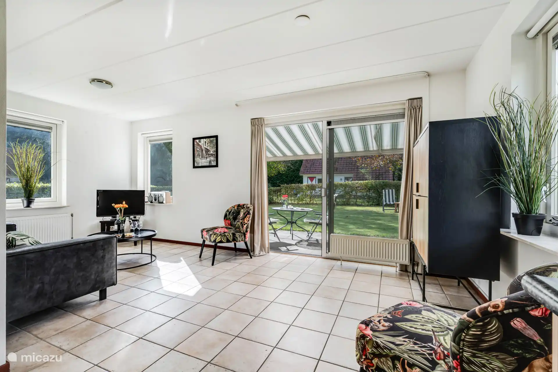 Woonkamer met zithoek en uitzicht op de tuin