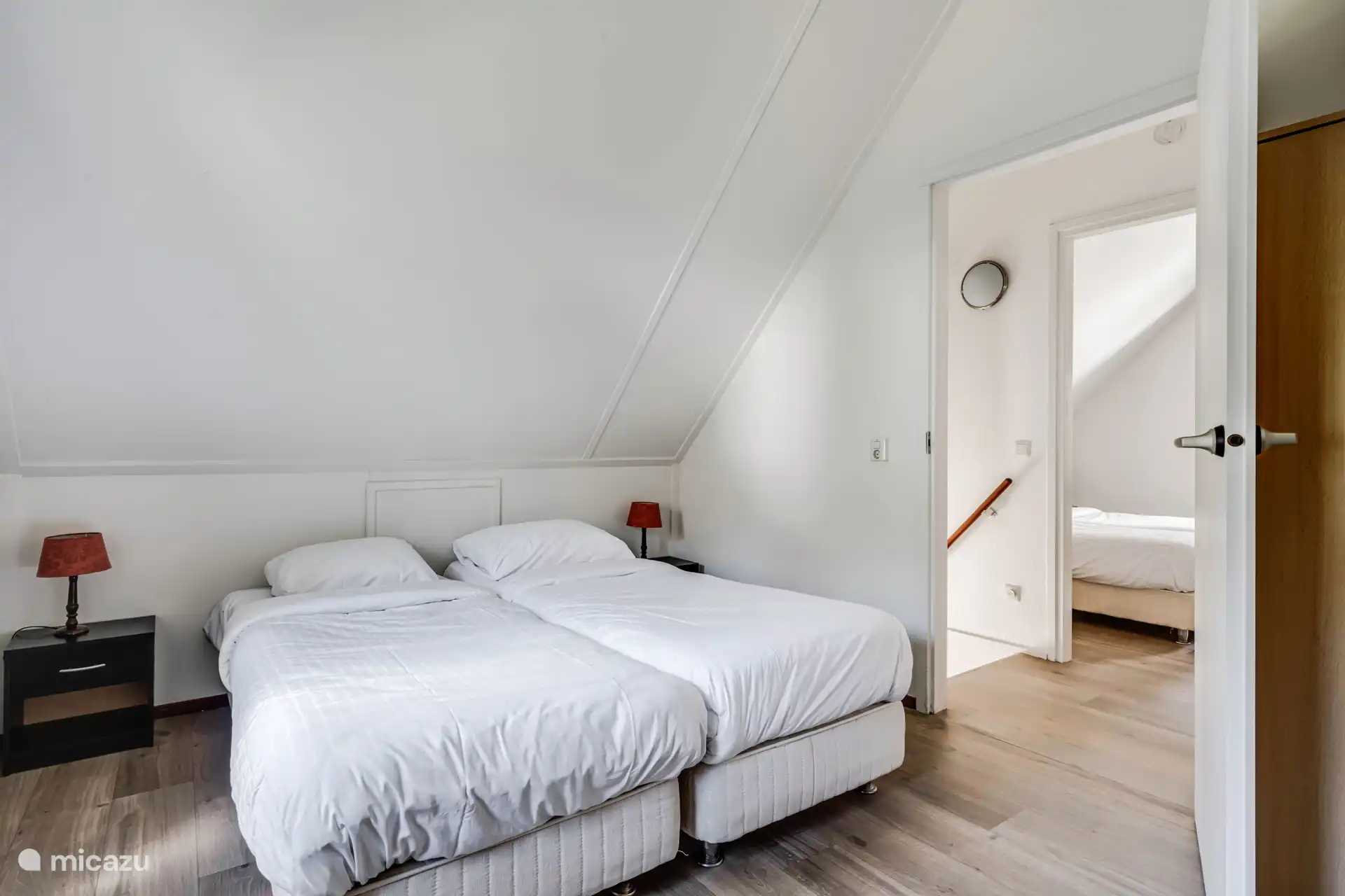 Slaapkamer met tweepersoonsbed en schuine wanden