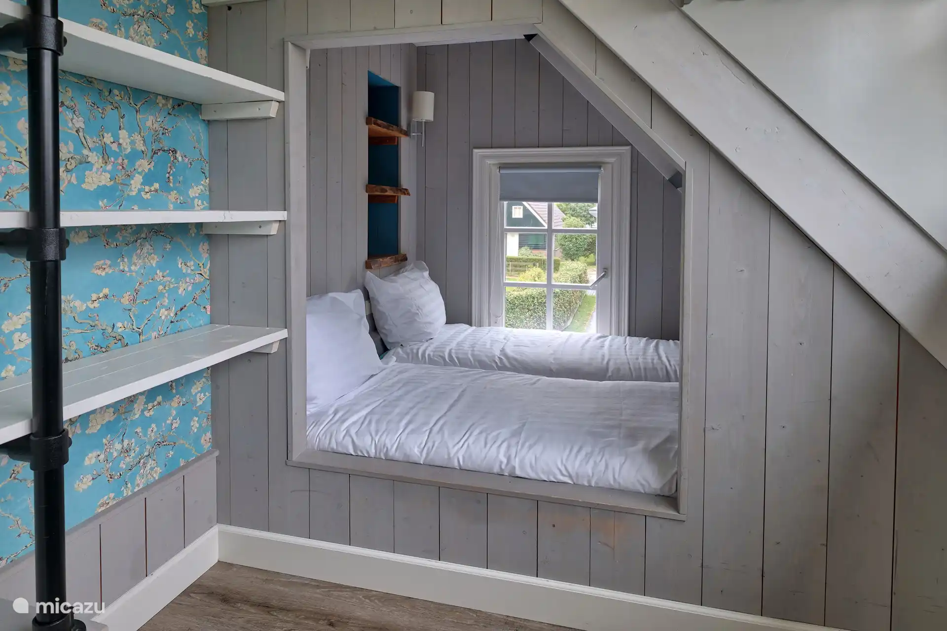 Sfeervolle slaapkamer met een klapbed met daarop een topper.