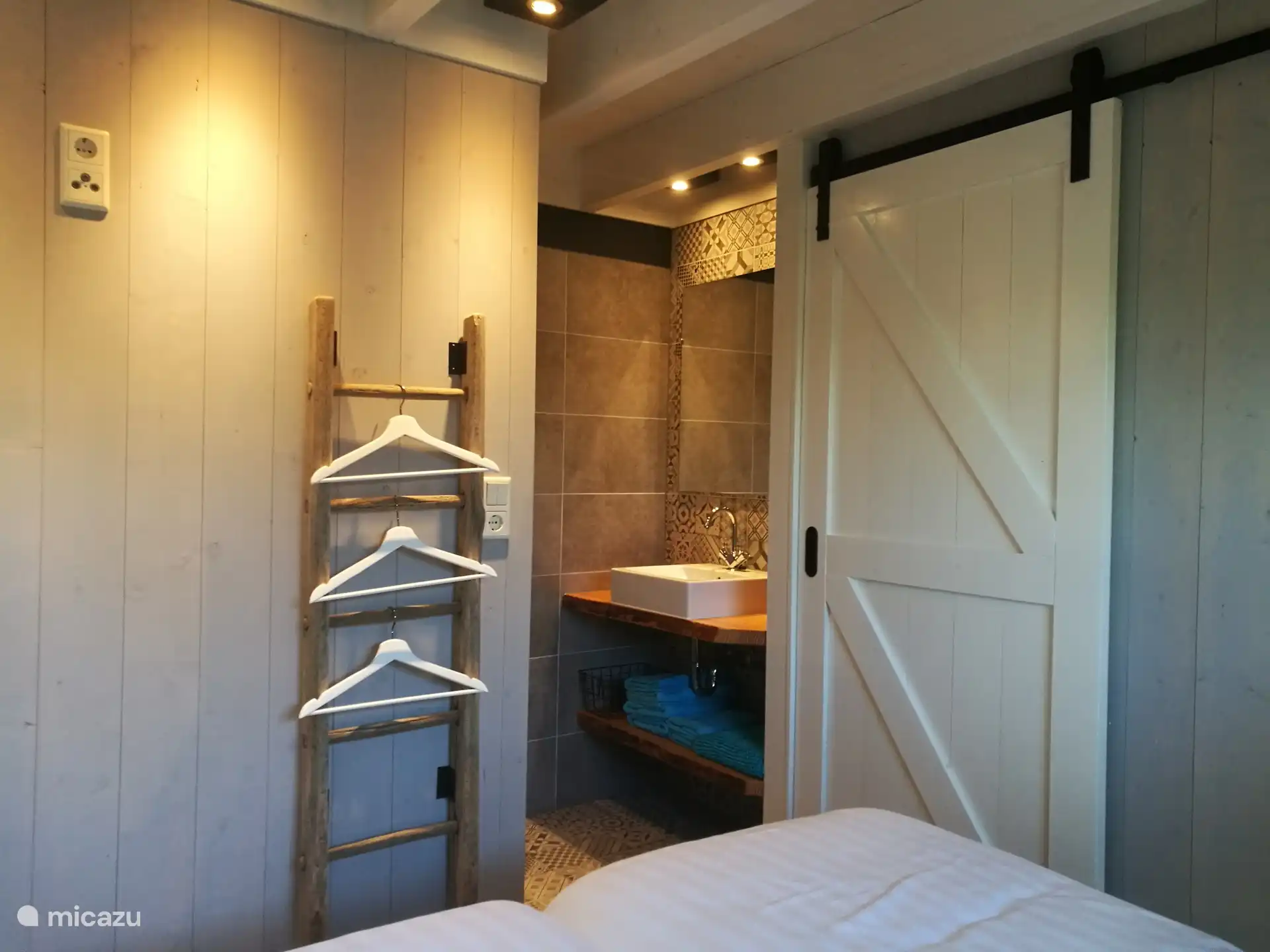 Beneden is een slaapkamer met badkamer en-suite, ideaal voor gasten die liever beneden slapen,